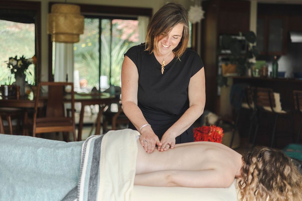 A massage therapist performs a relaxing therapeutic treatment on a client in a tranquil spa setting.