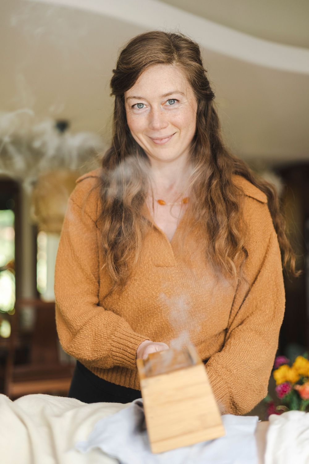 A series of lifestyle portraits showing someone in a cozy orange sweater lounging on white bedding.