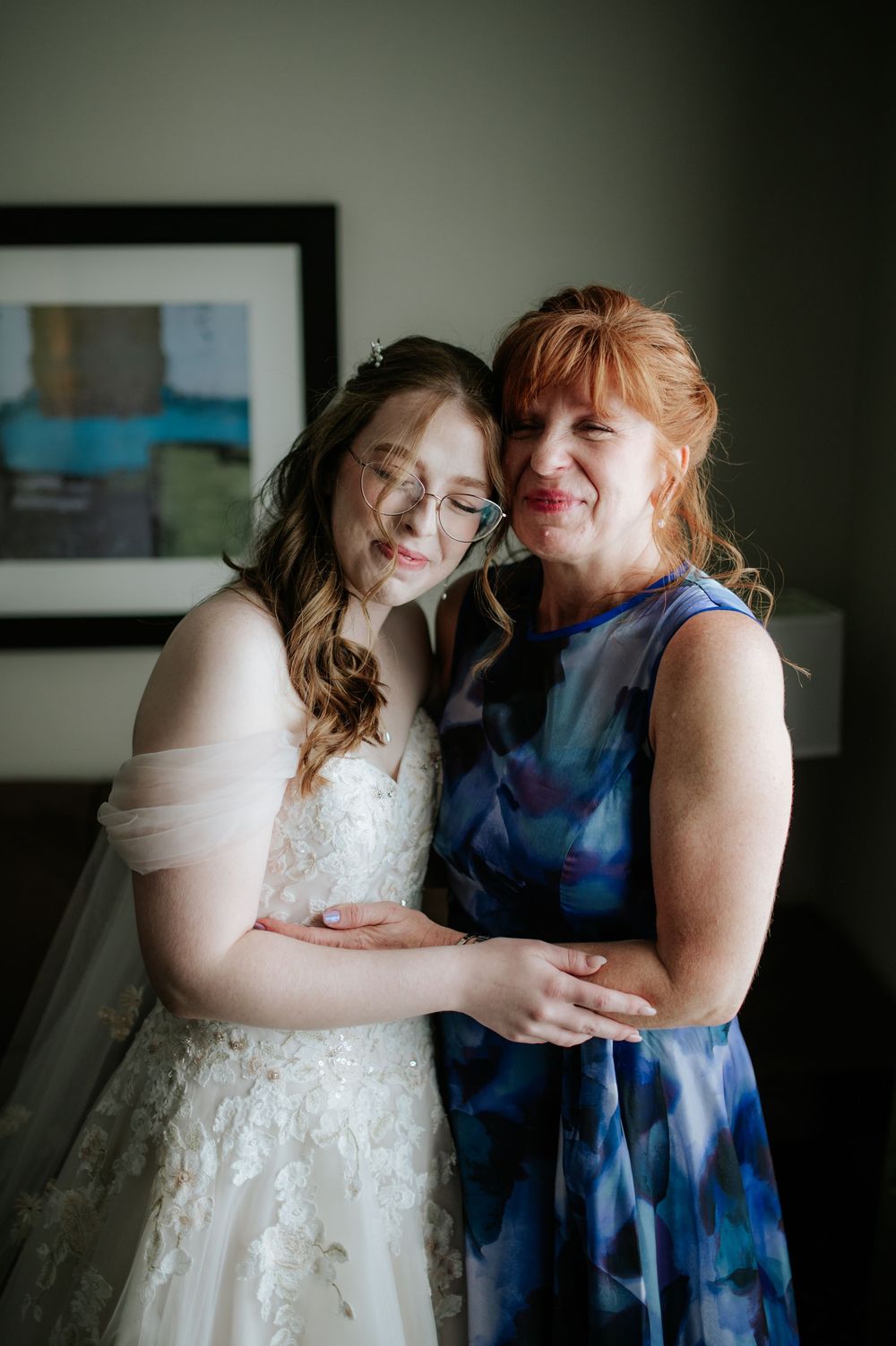 Two people sharing an intimate moment, one in a white dress and another in navy blue.