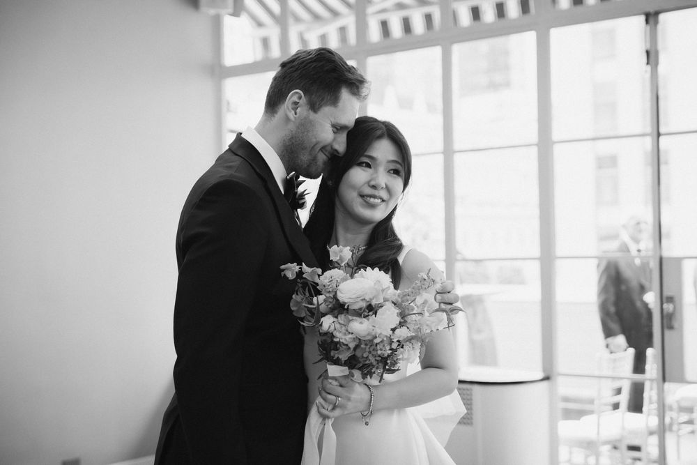 Black and white wedding photos showing intimate moments in a bright indoor venue.