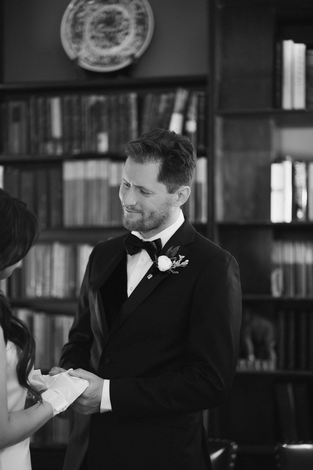 Intimate moment captured in black and white during a library wedding ceremony.