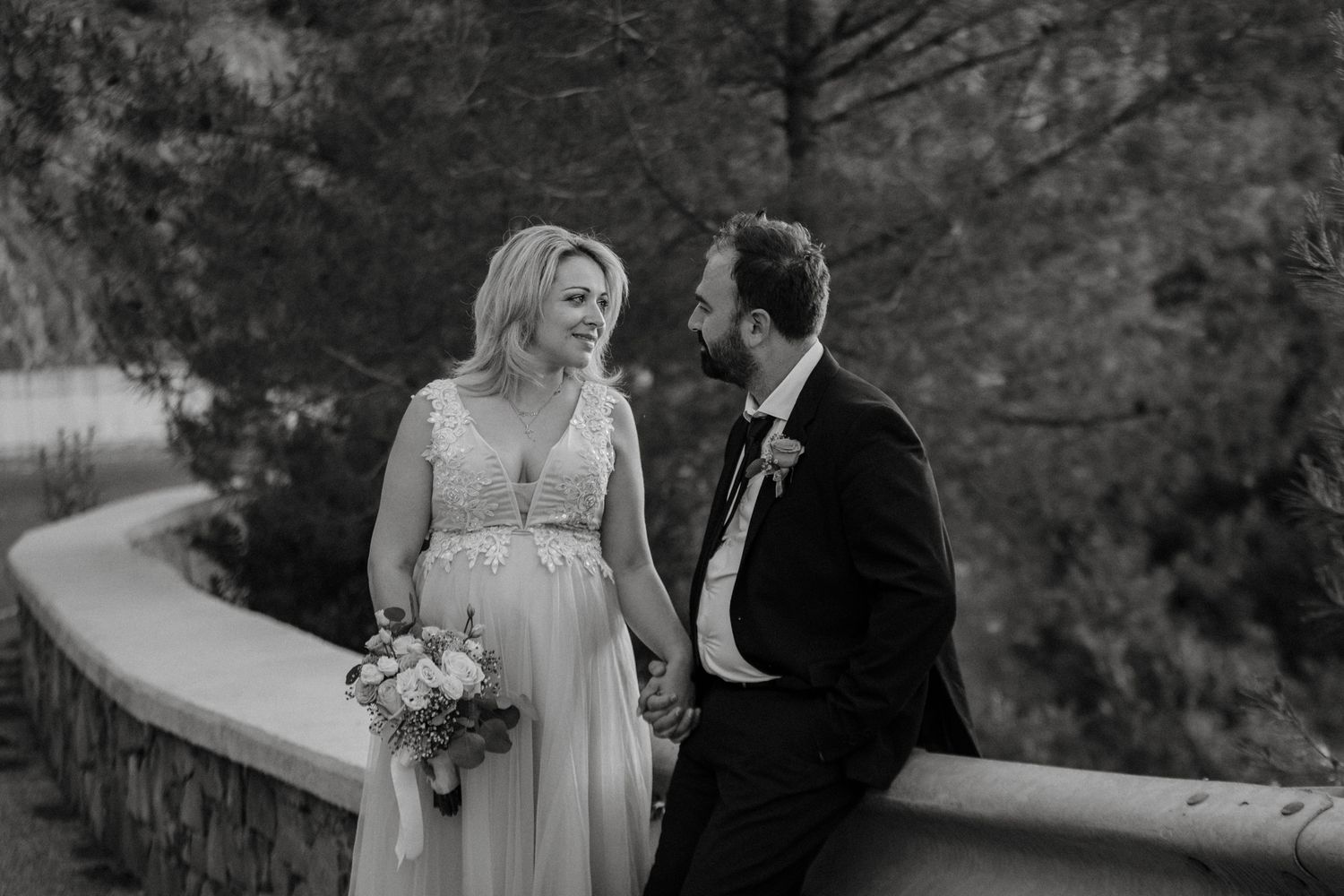 A romantic black and white wedding photo series showing tender moments between a bride and groom outdoors.