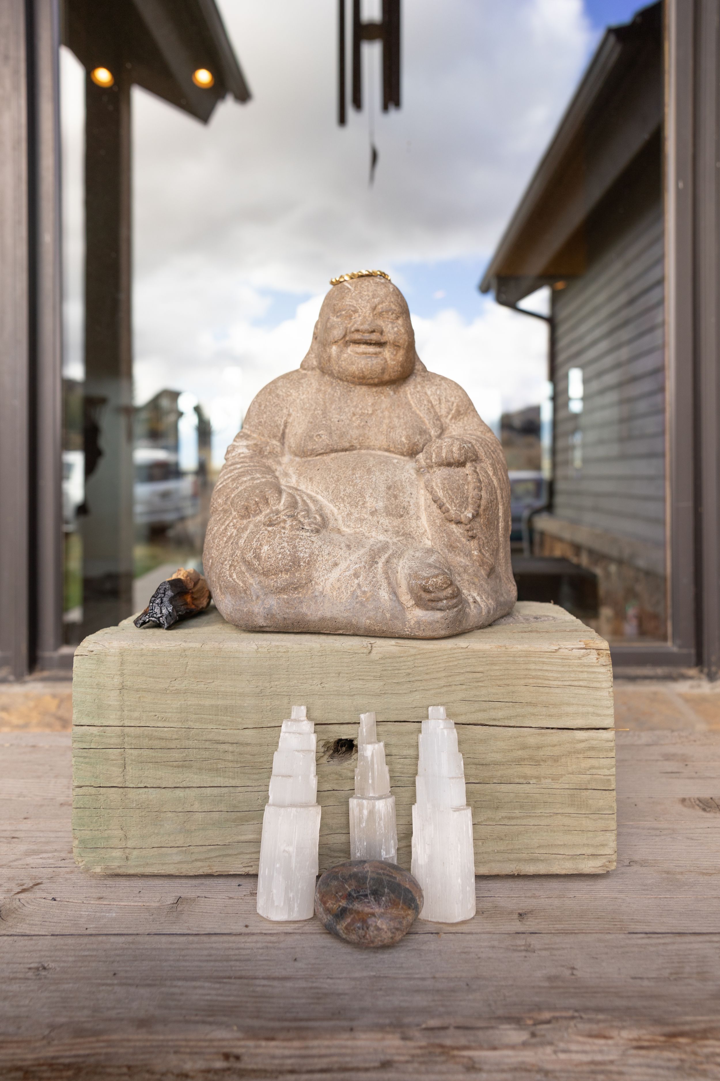 A sequence of stone sculptures displayed on wooden blocks with small glass bottles arranged in front.