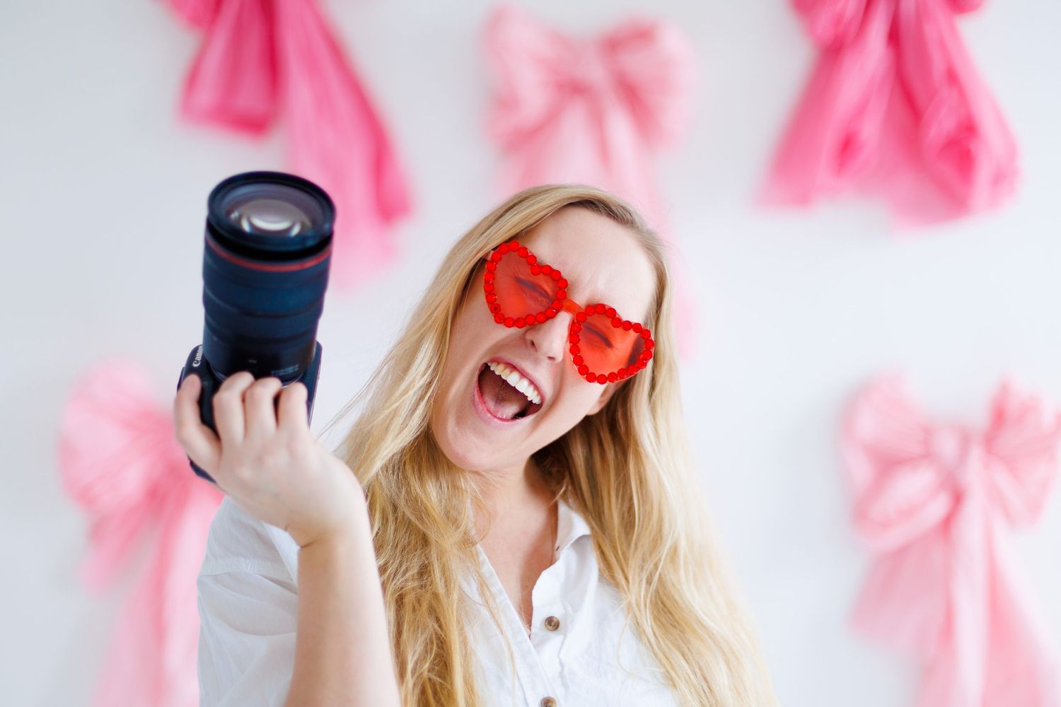 Pink flower petals float around a playful photo session with heart-shaped sunglasses and fun poses.