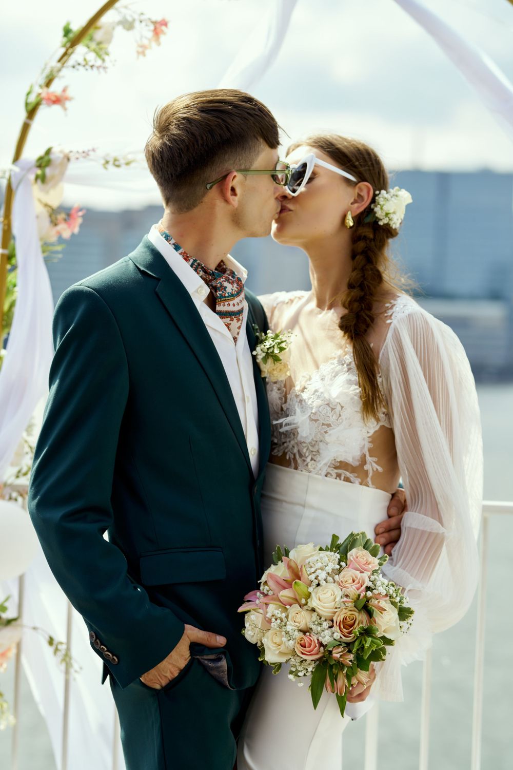 Romantic wedding couple shares intimate moments against a waterfront backdrop.