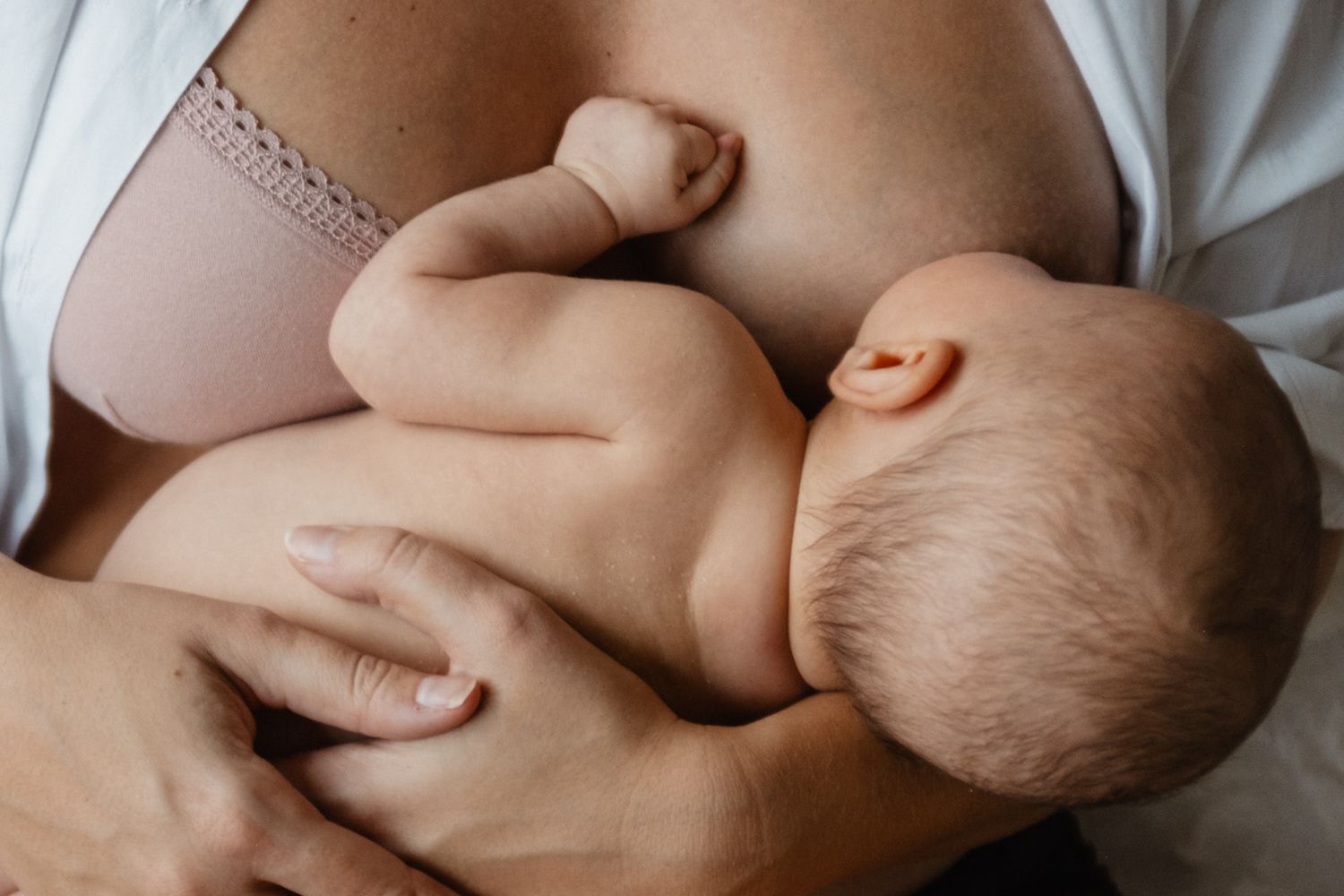 Photo d'allaitement tres douce, un bebe de 12 jours nourrit au sein, un moment capture par une photographe de naissance lifestyle a Lille