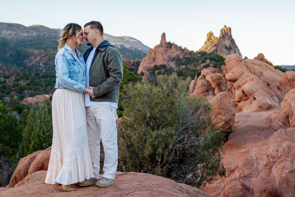 Intimate portrait on red rocks with Cathedral Rock formation visible in the background.