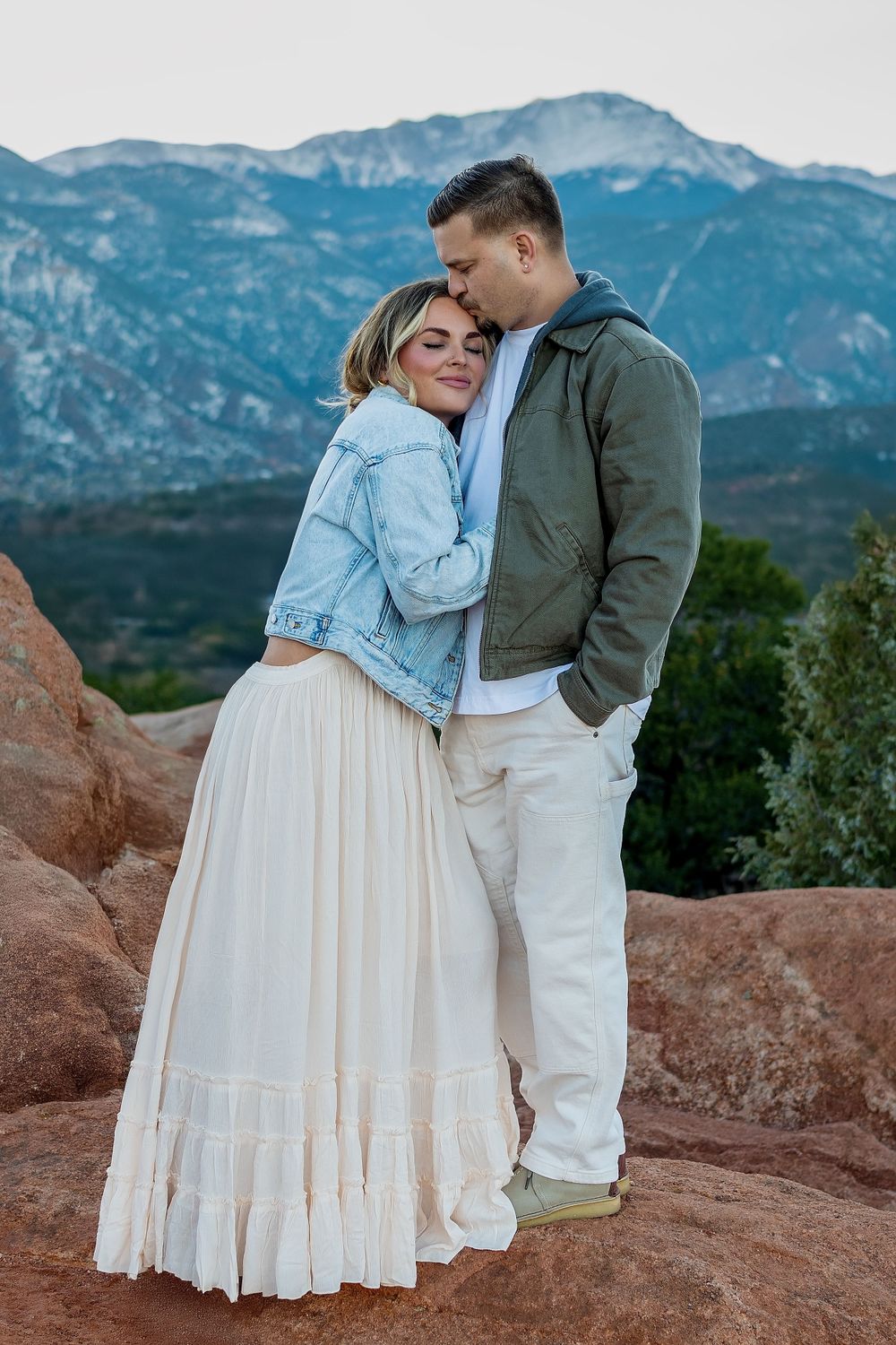 A romantic moment captured against a backdrop of majestic mountains and red rocks.
