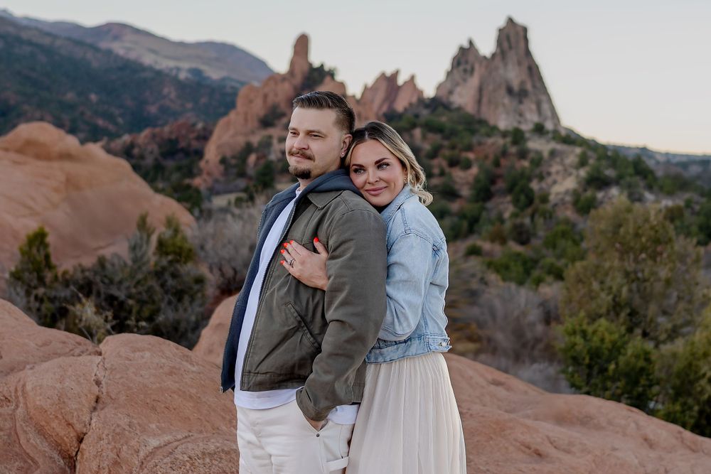 A couple poses against the iconic red rock formations of Garden of the Gods in Colorado.