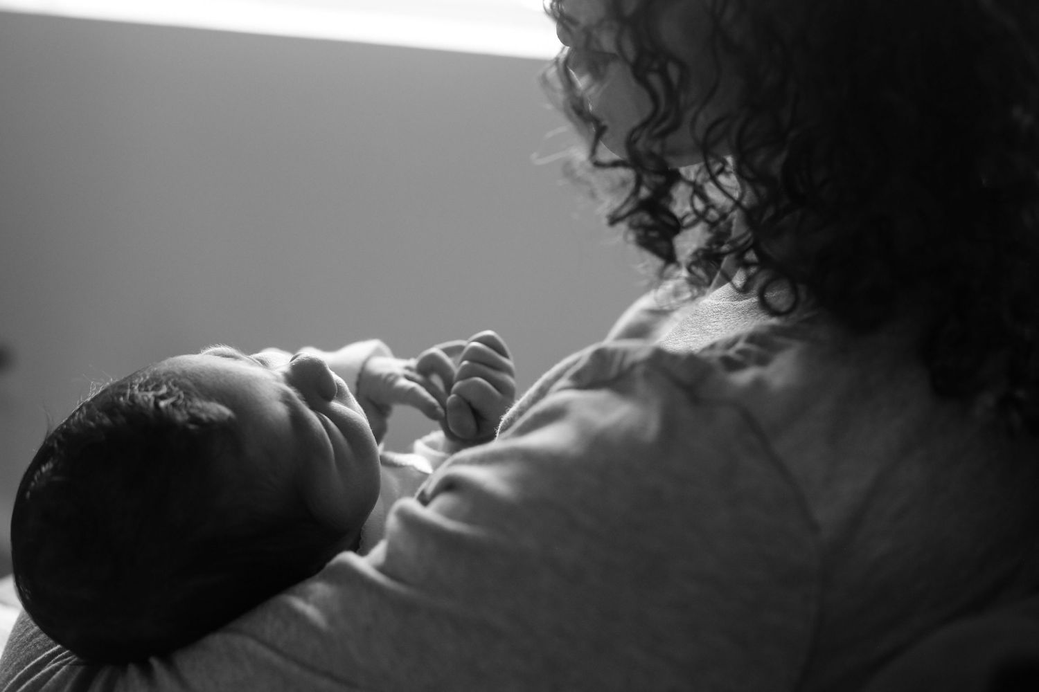 Intimate black and white portrait of a tender moment with a newborn.