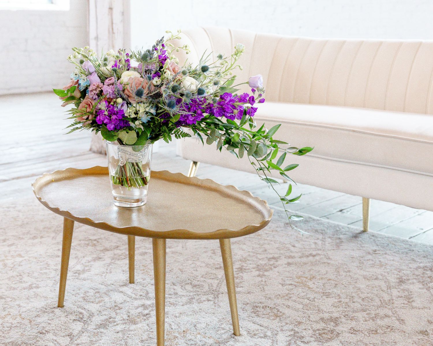 Elegant floral arrangement with purple and pink blooms on a gold accent table in Brainerd, MN.