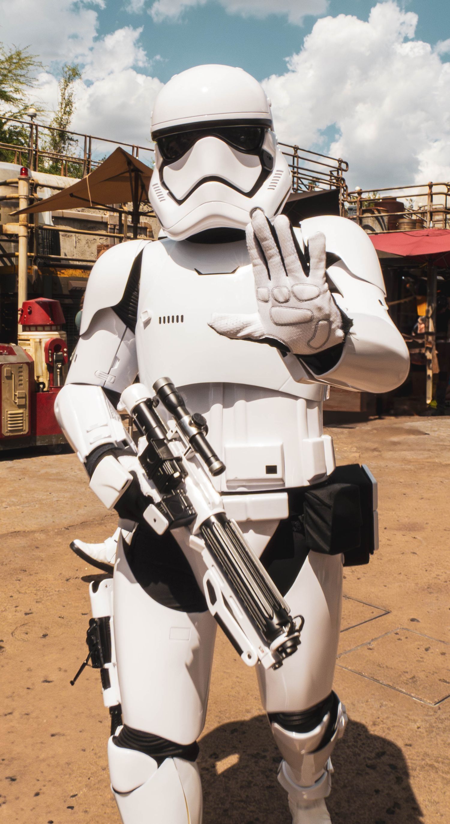 Four Star Wars Stormtroopers in white armor pose with blaster rifles at Galaxy's Edge theme park attraction.