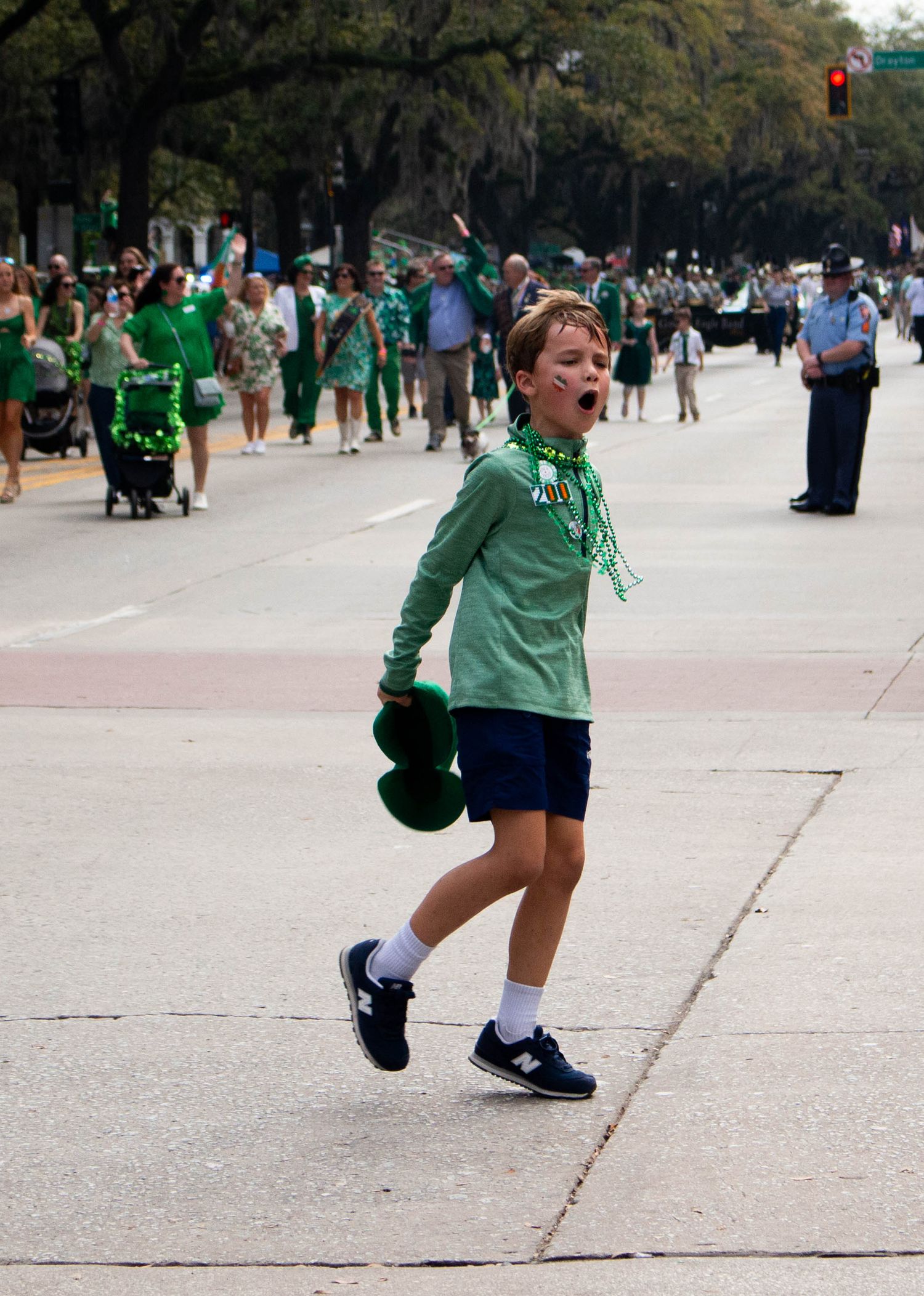 A person in green attire celebrating during a St. Patrick's Day parade.
