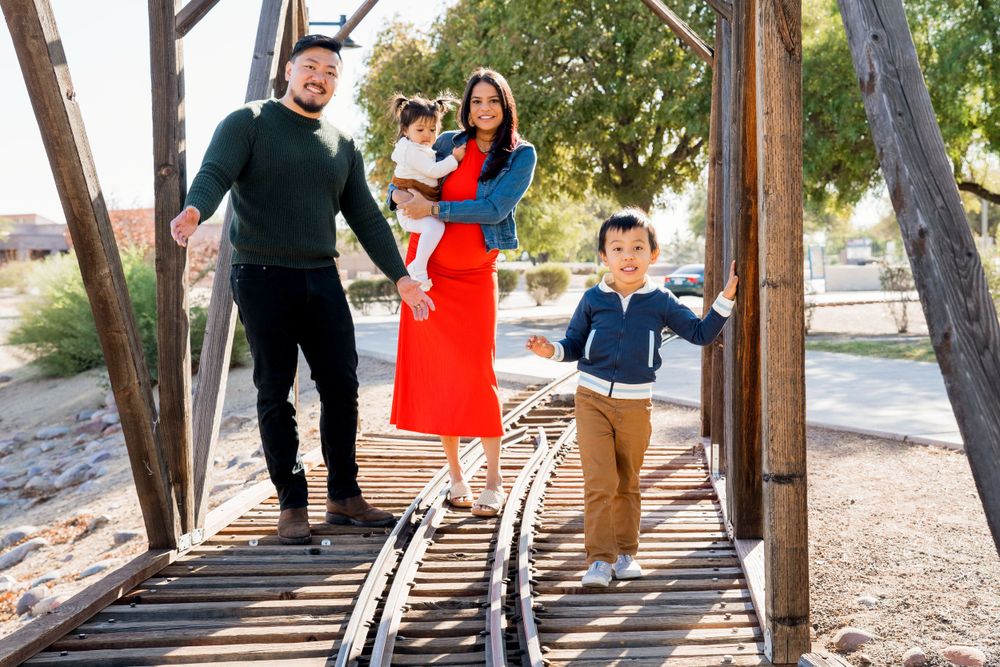 A family enjoying time together on a wooden bridge outdoors.