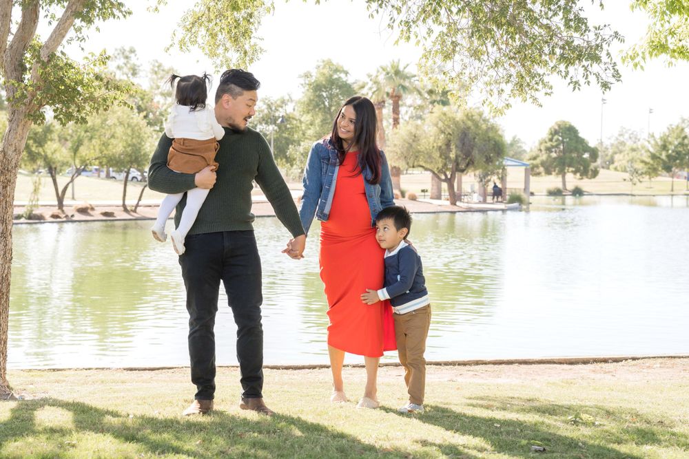 A family enjoys time together near a serene lake on a bright afternoon.
