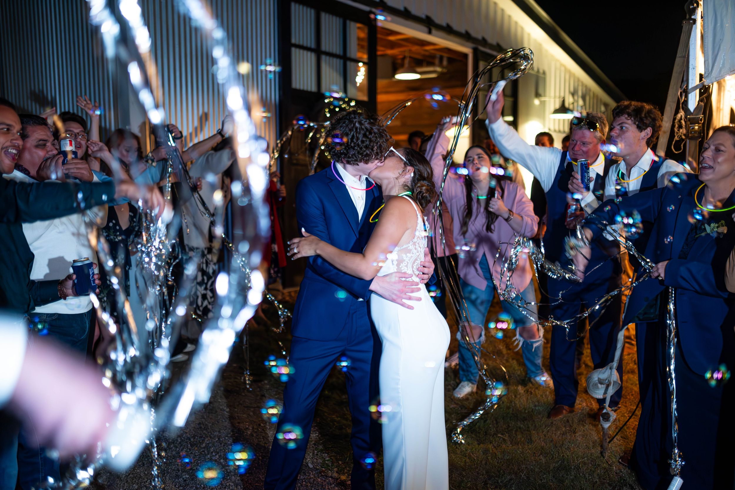 Couple shares romantic dance moment under confetti and lights at evening reception.