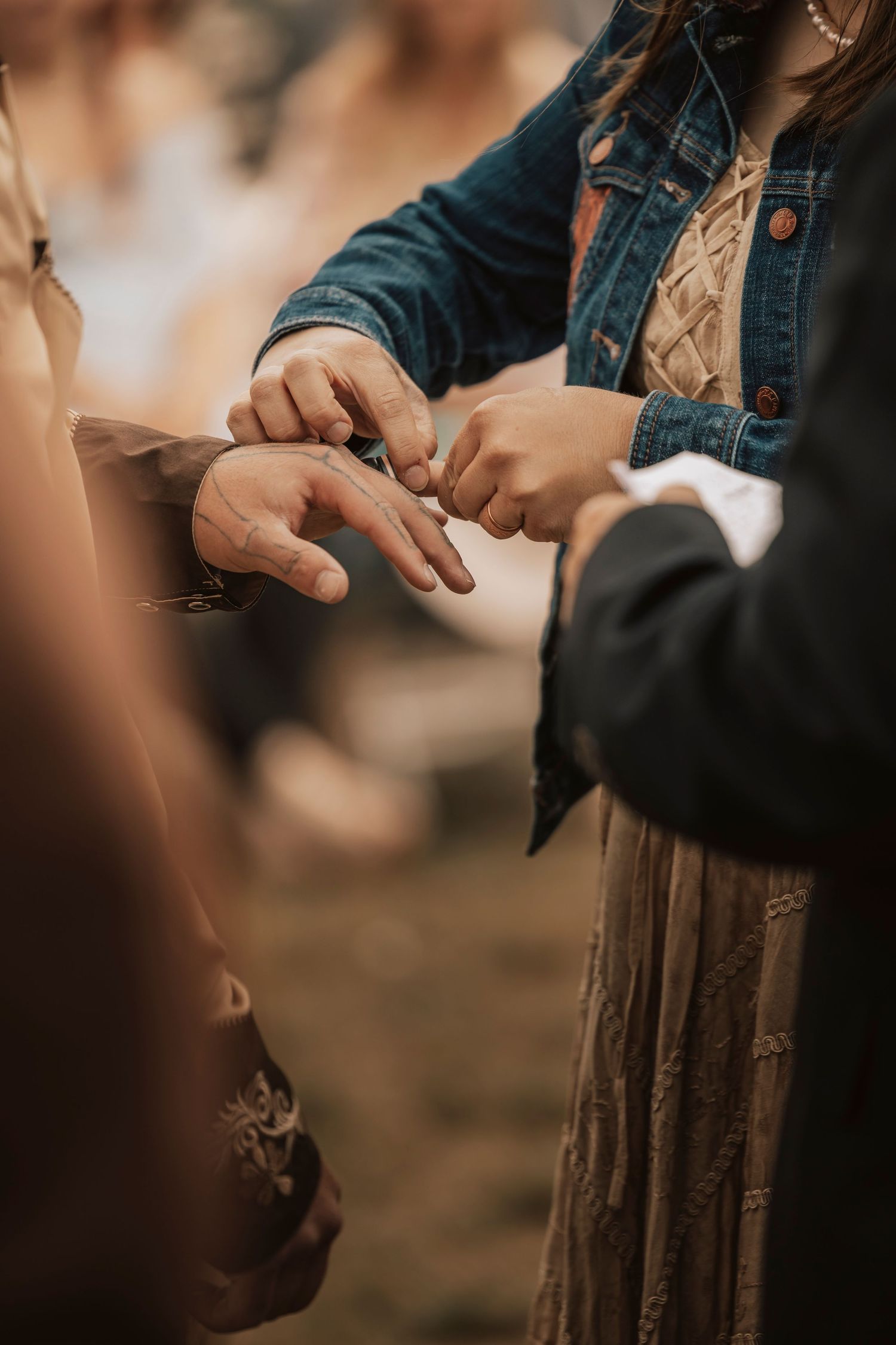 Close up photo of weddings bands being placed onto finger