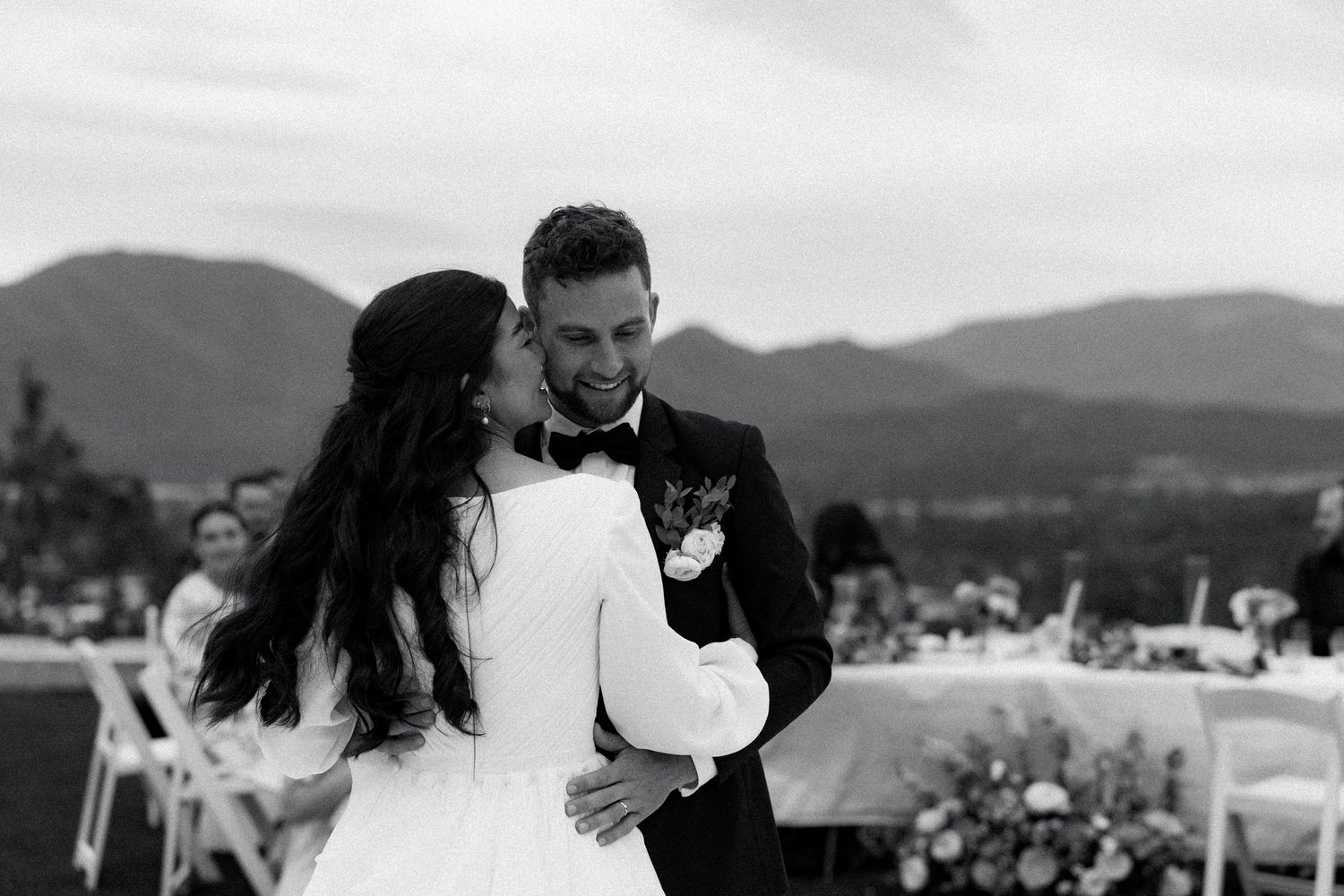 A couple shares a romantic dance at their mountain-view wedding reception.