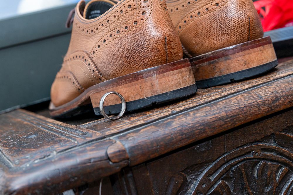 A pair of brown leather dress shoes on a wooden surface.