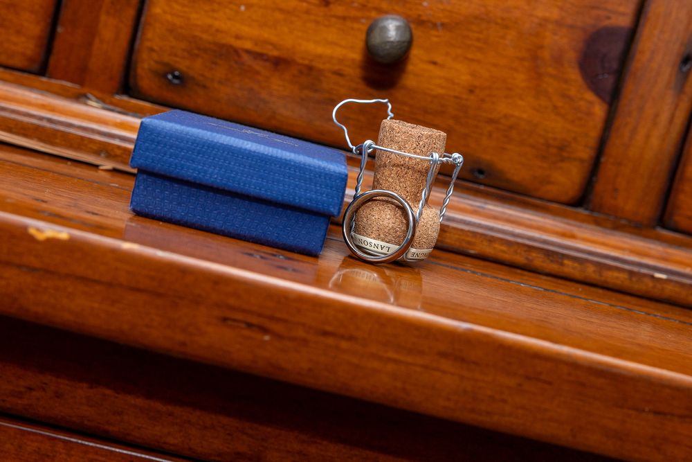 An image showing a stack of blue books with a metal ring on top of them on a wooden surface.