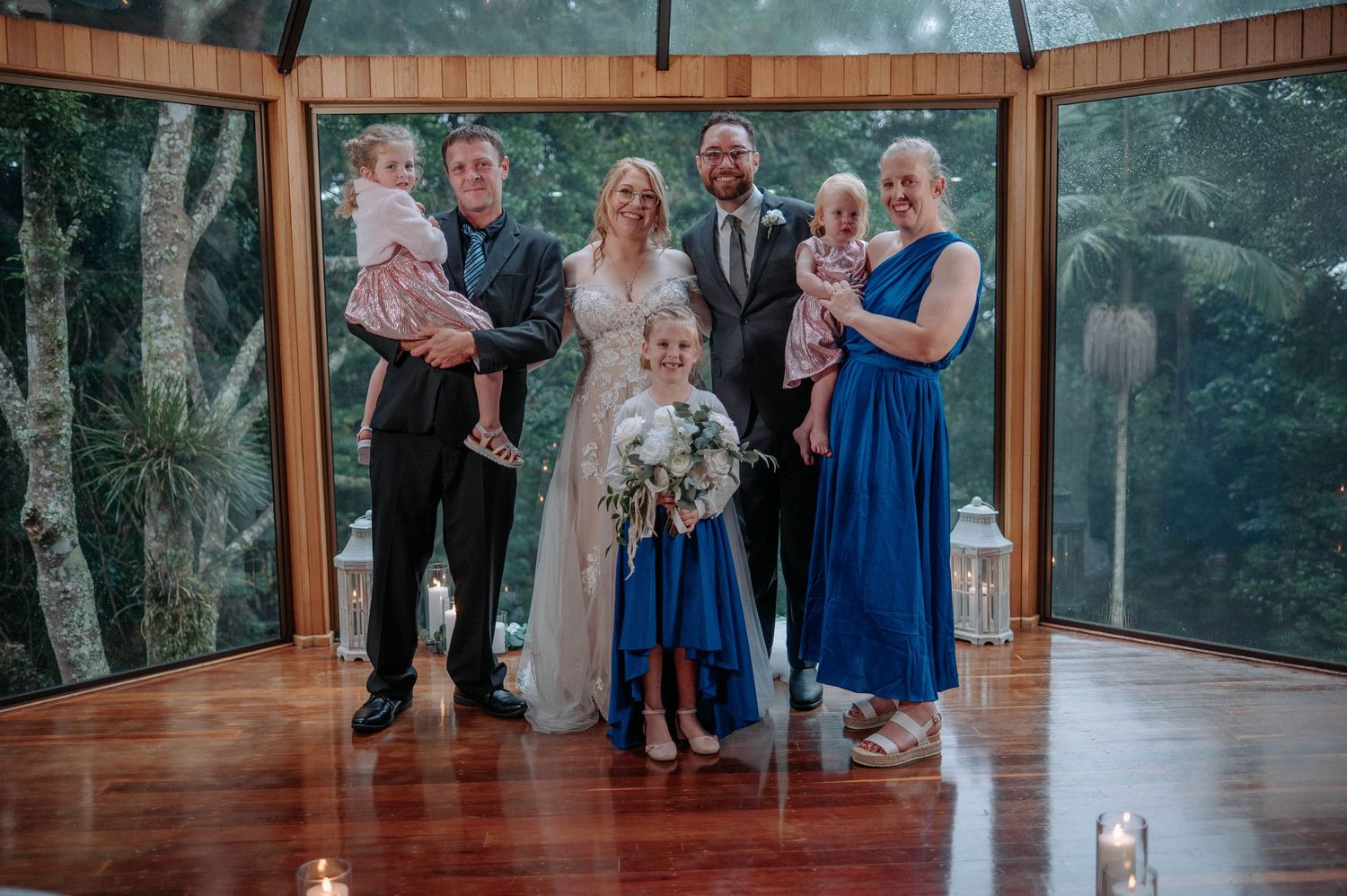 Family group photo at wedding celebration in wooden gazebo.