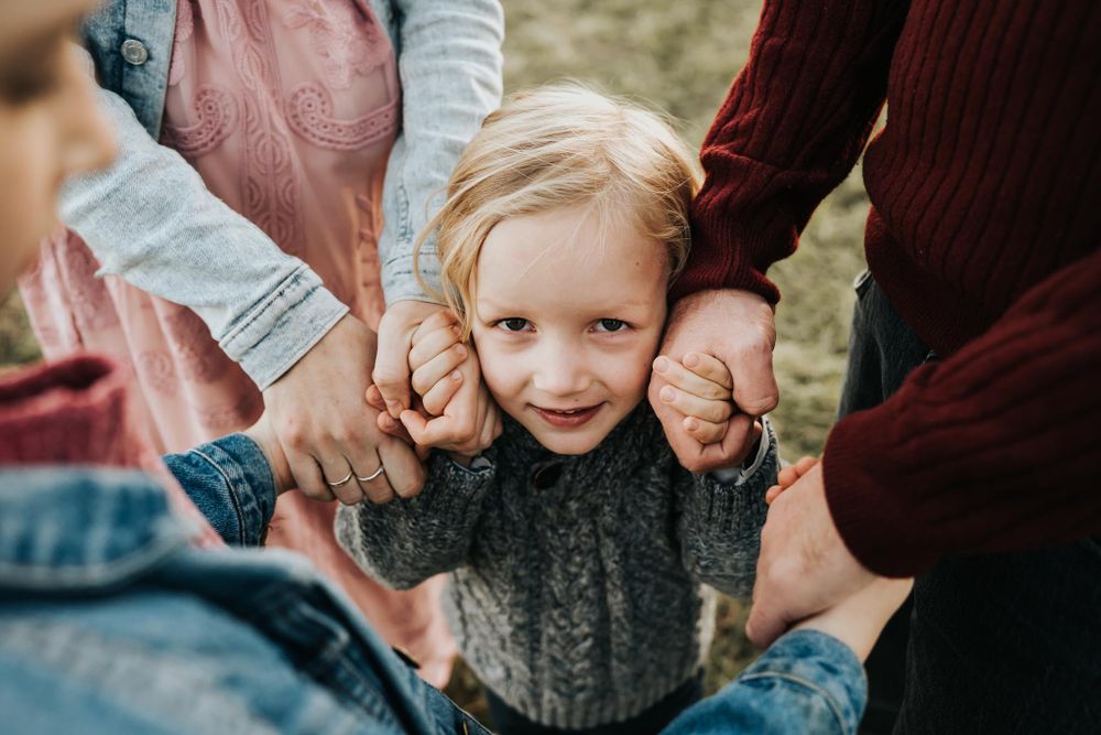 mama i tata trzymają za rączki synka - sesja w plenerze Kraków