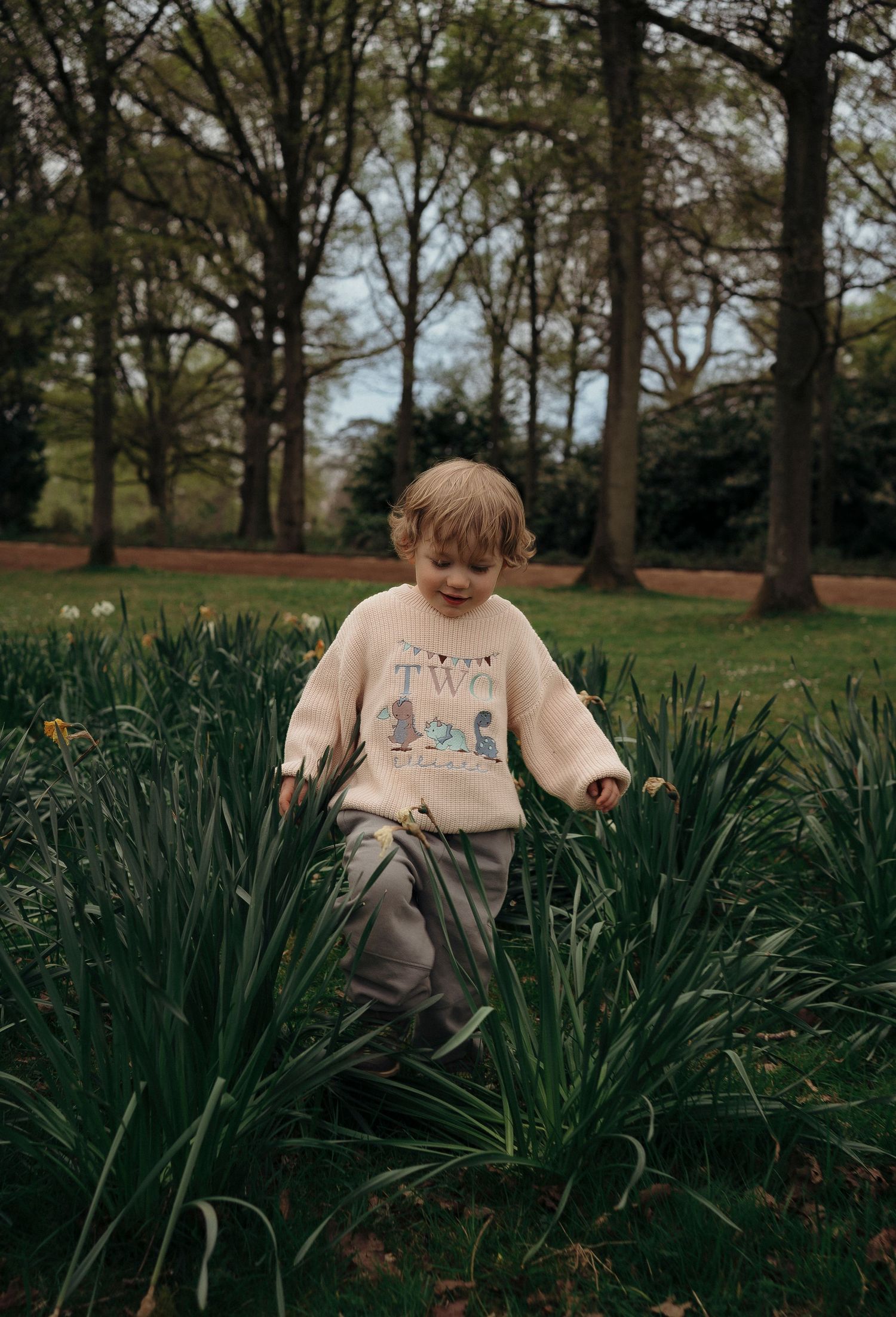 Toddler playing in long grass at Cotswold Wildlife Park captured by Shayla Bloom Photography