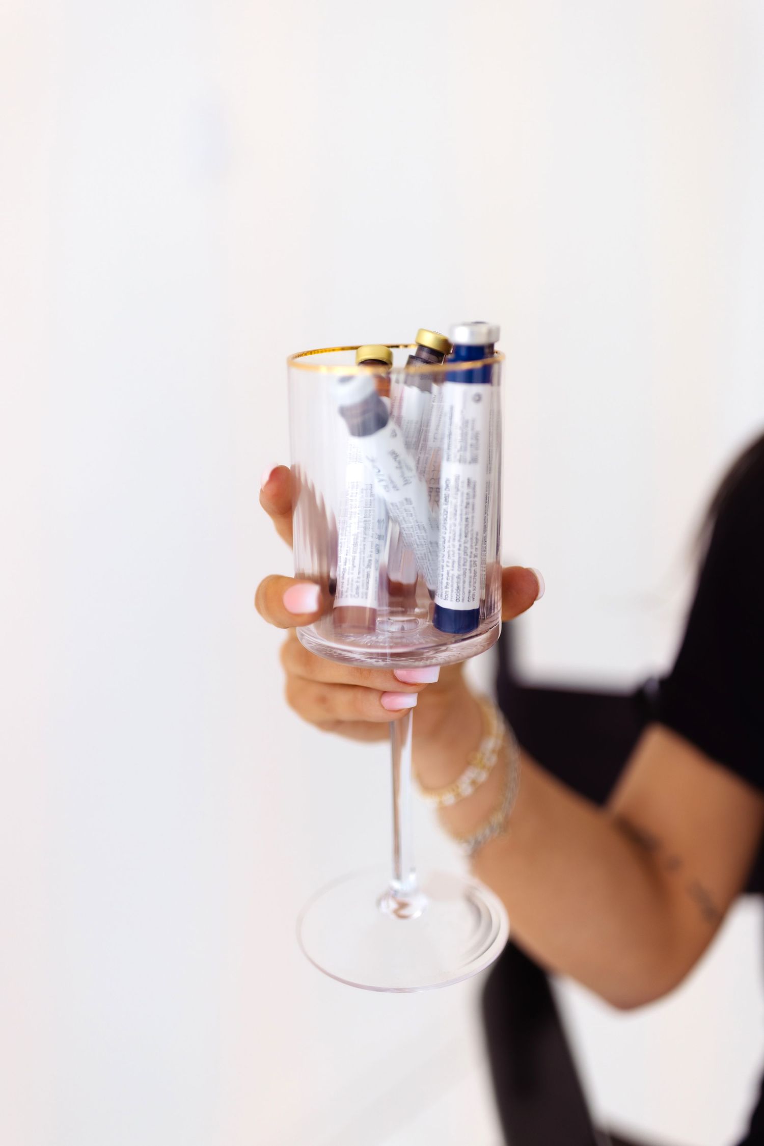 Hand holding an elegant champagne glass with several rolled-up cloth napkins garnishing the rim.