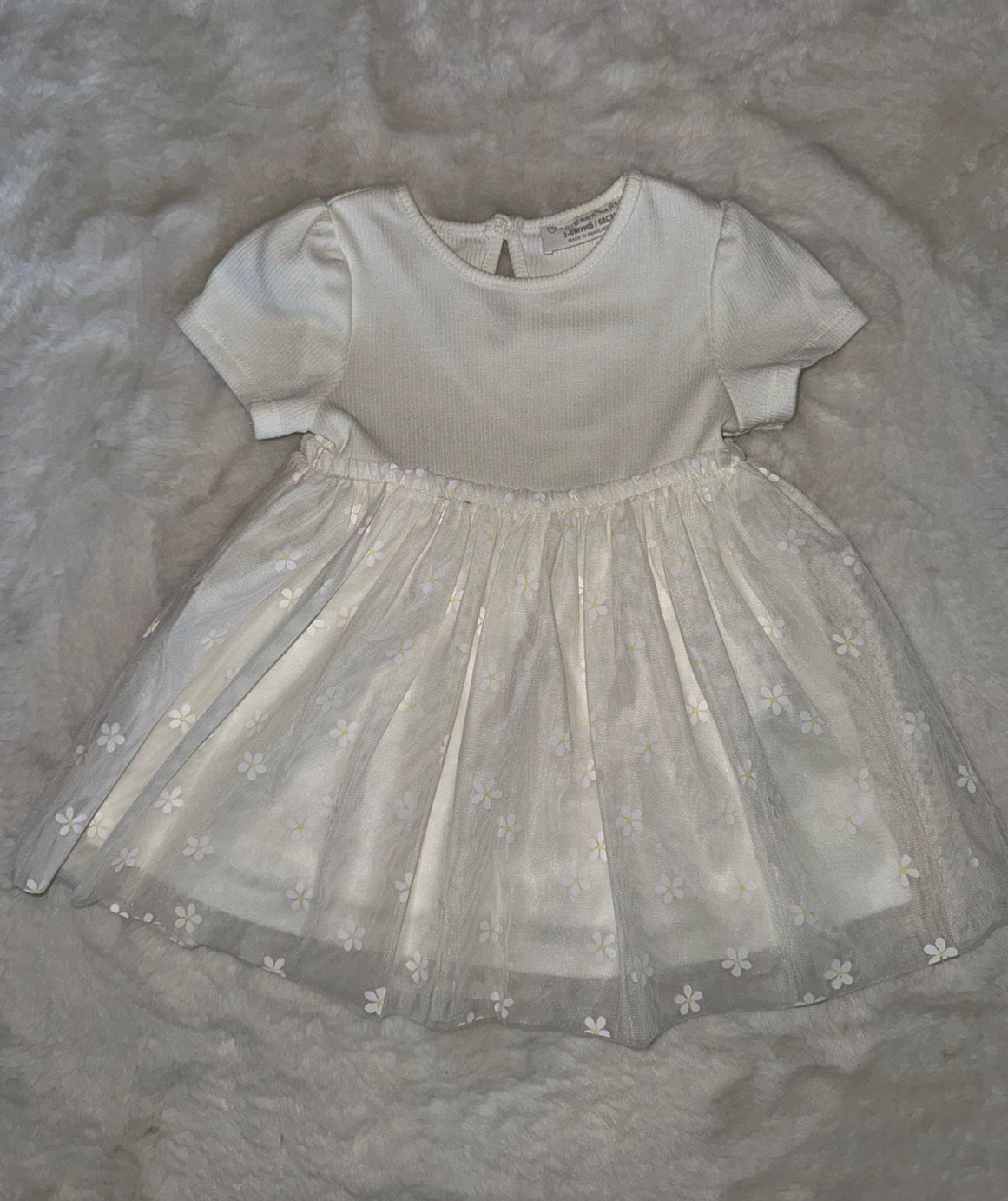 White eyelet baby dress with short sleeves and full skirt.