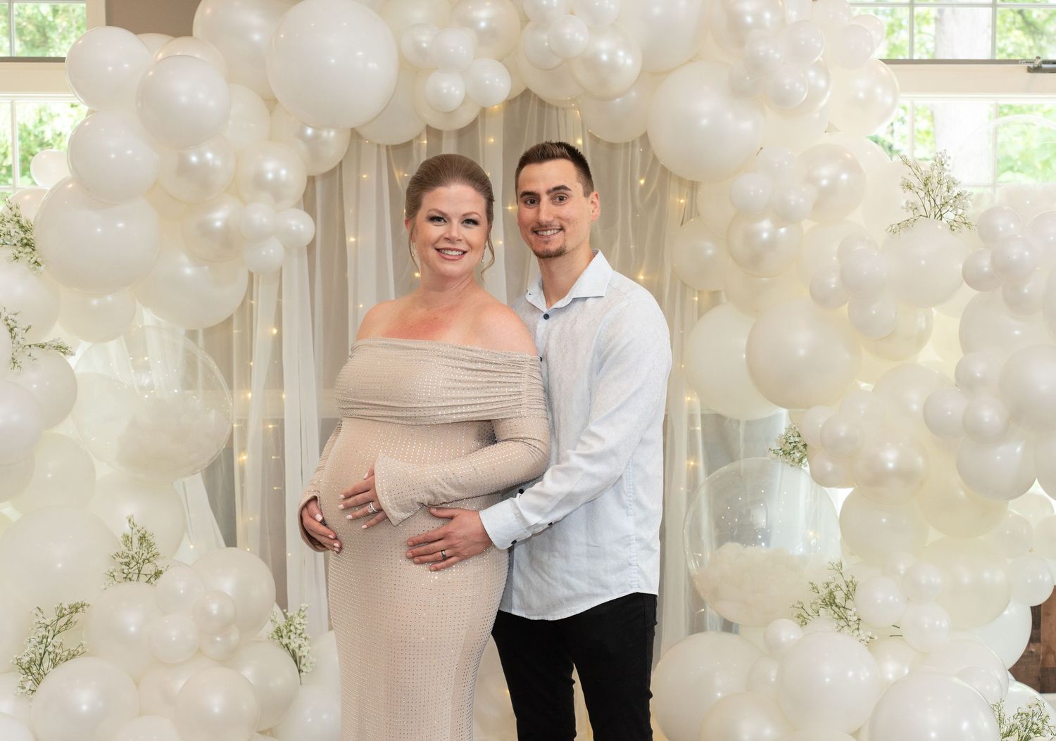 A baby shower  celebration setup with white balloons and decorative elements in an elegant indoor space.
