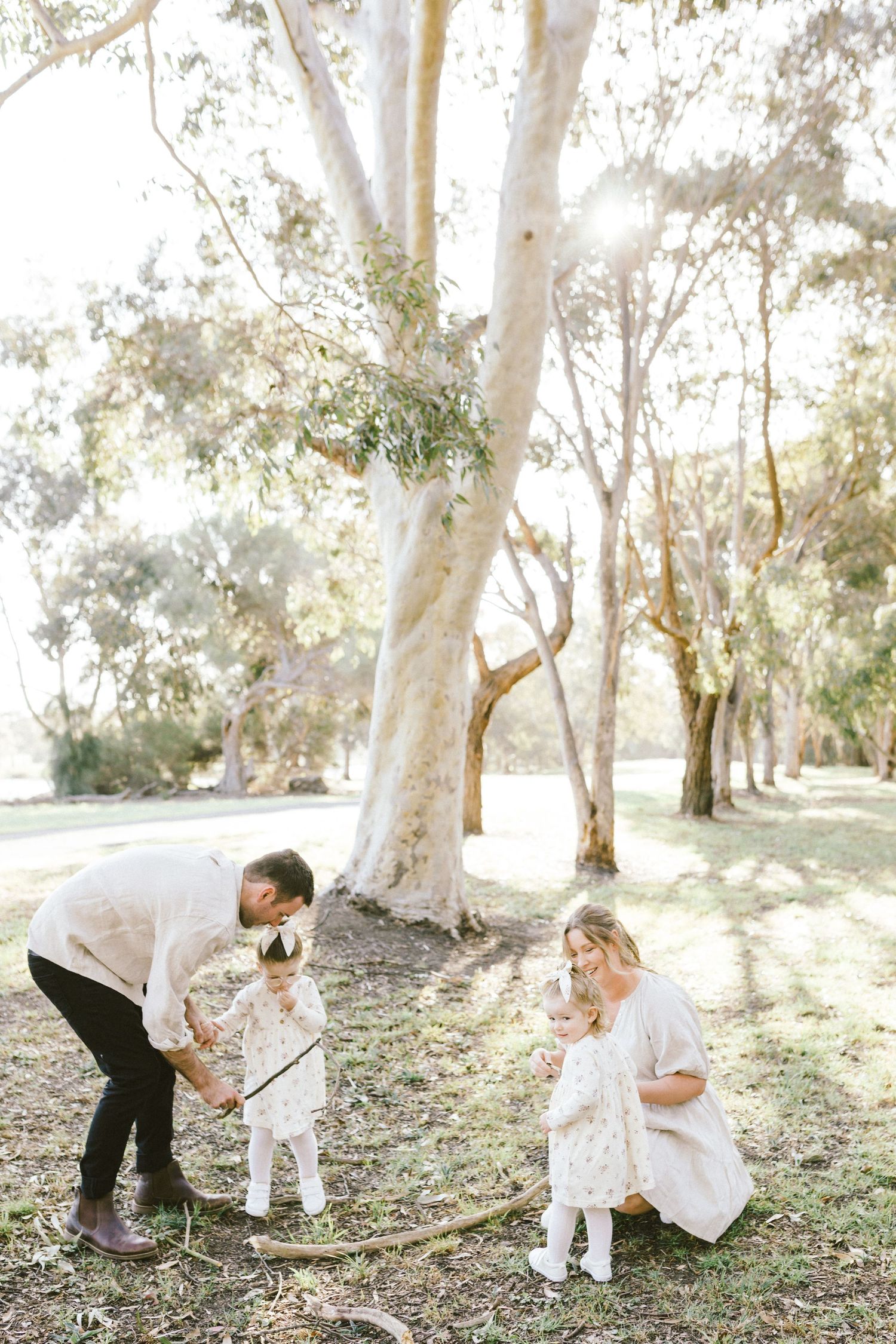 Bride and groom share intimate moments under eucalyptus trees in a serene outdoor setting.
