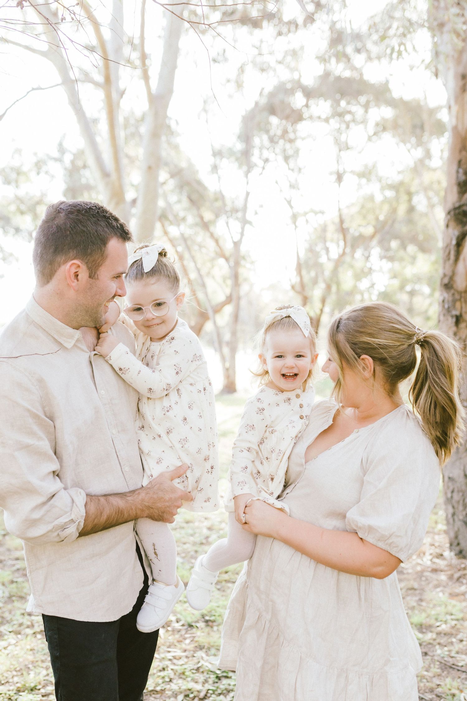 Four candid moments of family affection and laughter captured in a sunny outdoor setting with white attire.