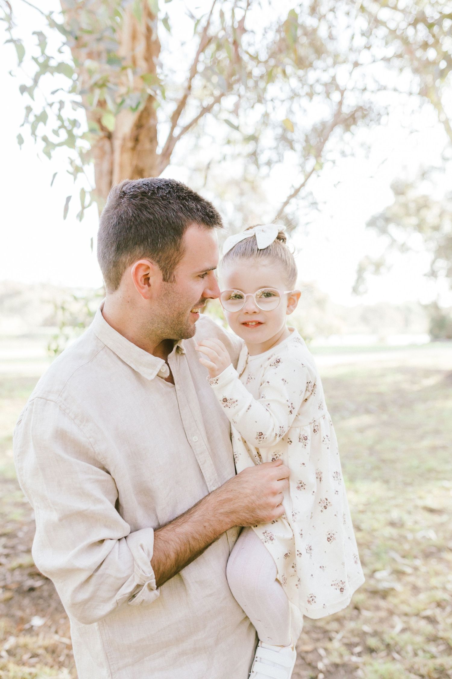 A tender moment between a parent and child playing together outdoors in soft autumn light.