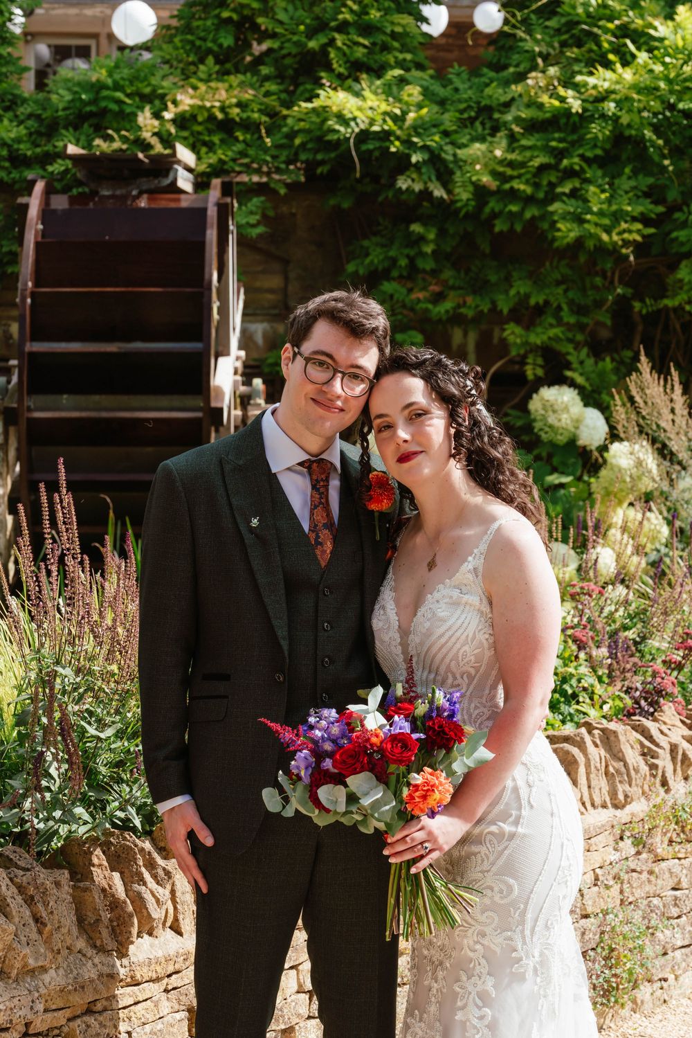 The Frogmill wedding venue Cheltenham Cotswolds Gloucestershire couple posing in front of water wheel