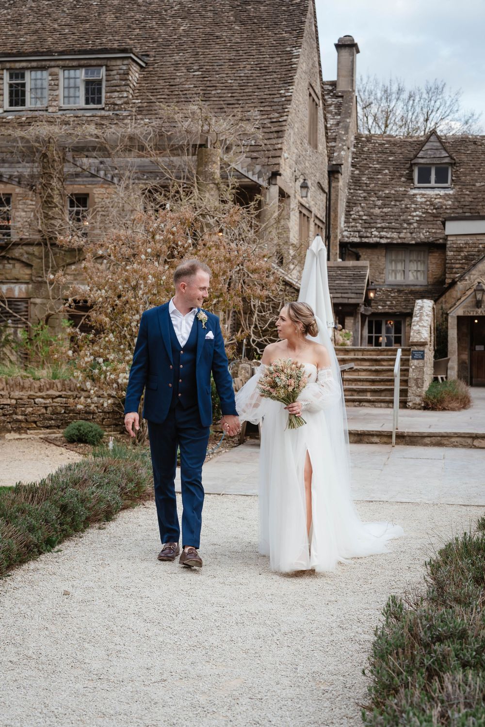 The Frogmill wedding venue Cheltenham Cotswolds Gloucestershire couple walking in front of venue