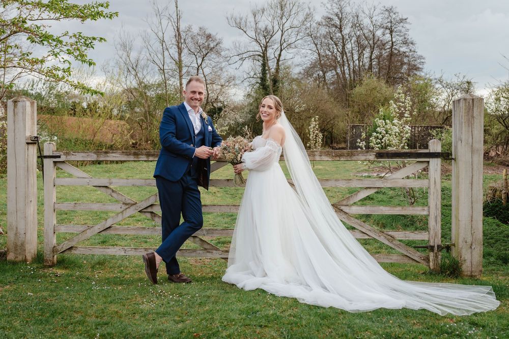 The Frogmill wedding venue Cheltenham Cotswolds Gloucestershire couple posing in front of wooden gate