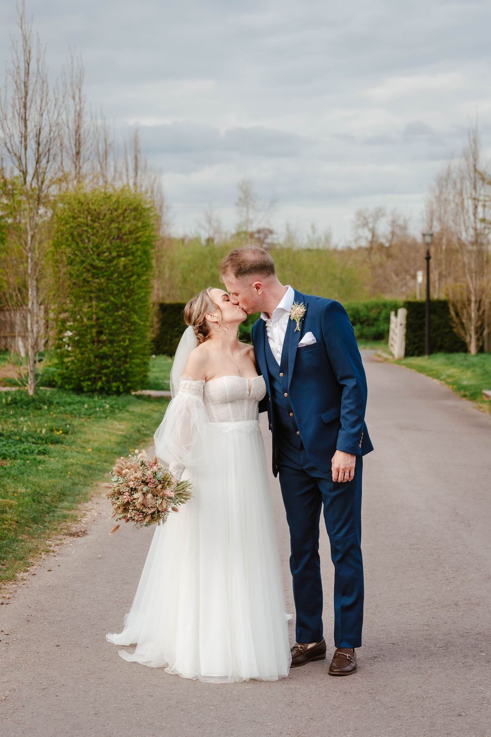 The Frogmill wedding venue Cheltenham Cotswolds Gloucestershire couple kissing on driveway