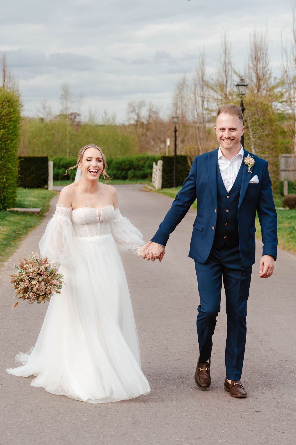 The Frogmill wedding venue Cheltenham Cotswolds Gloucestershire couple walking hand in hand on driveway