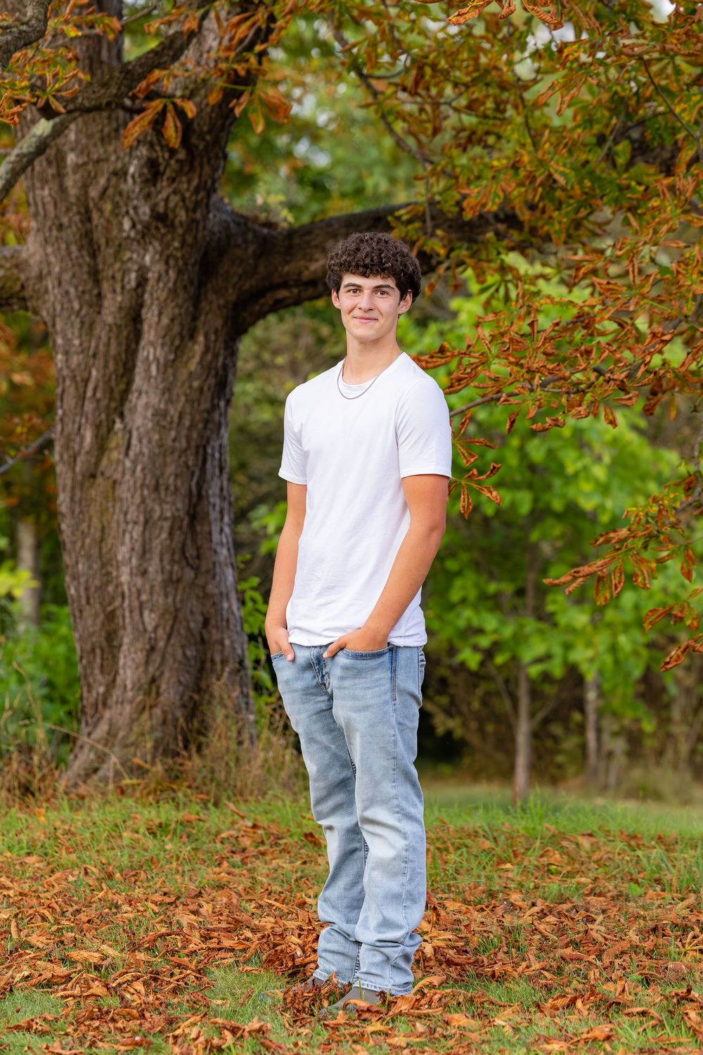 A series of autumn outdoor portraits featuring a person in a white t-shirt and jeans standing among fallen leaves.