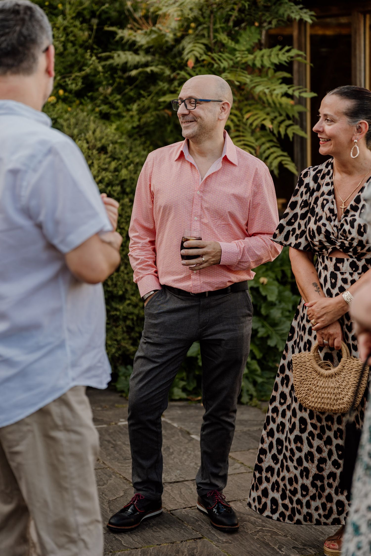 Casual outdoor gathering with guests in summer attire socializing.