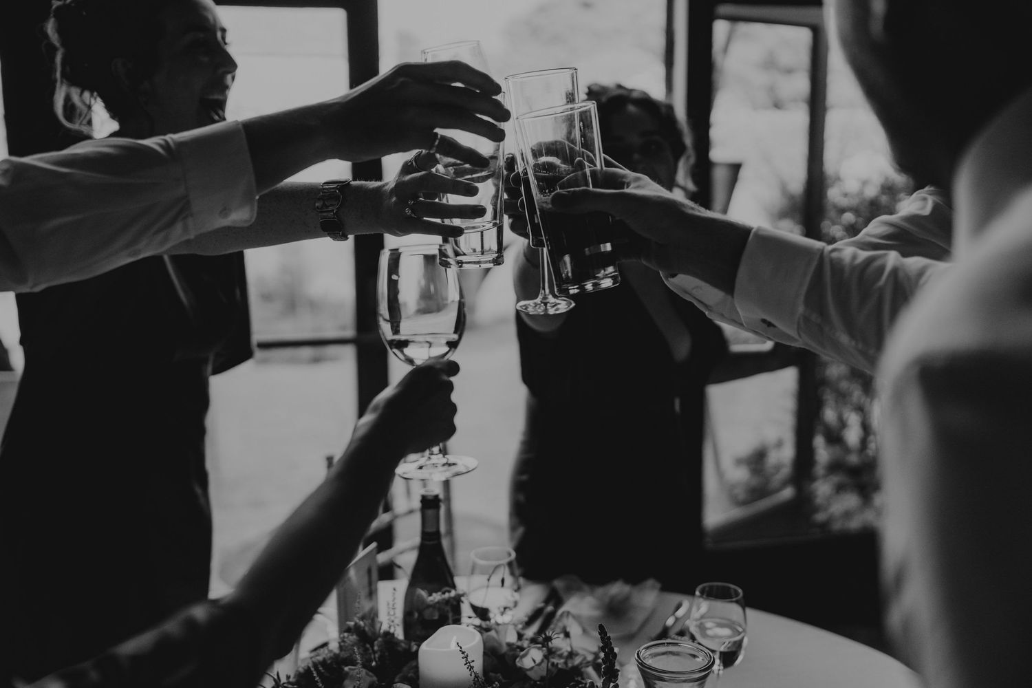 Wedding guests clink champagne glasses in celebration during an elegant reception.