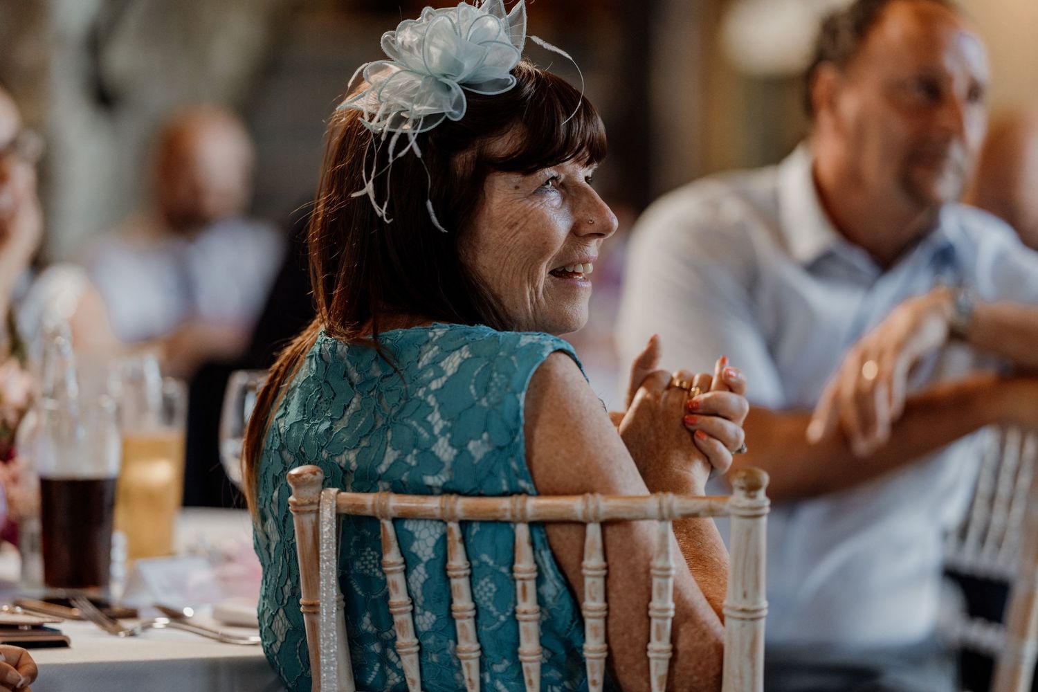 Wedding guests mingle and laugh together at a rustic barn reception venue.