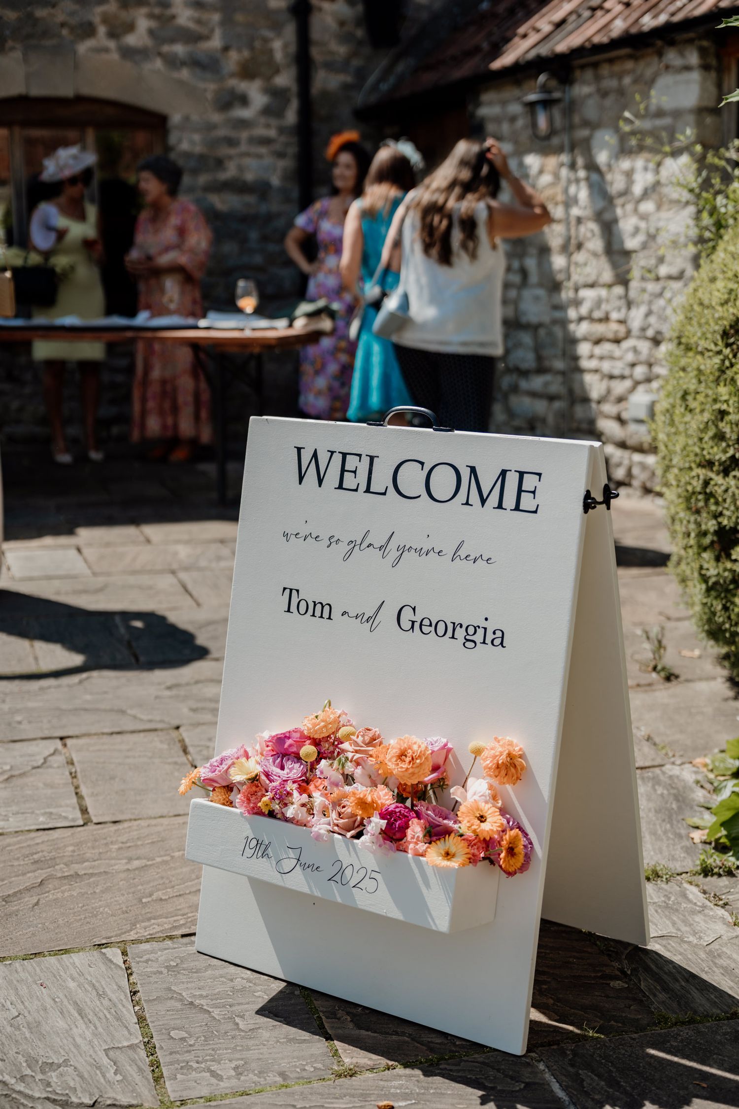 White place cards with floral decorations arranged on a rustic stone surface during a wedding celebration.