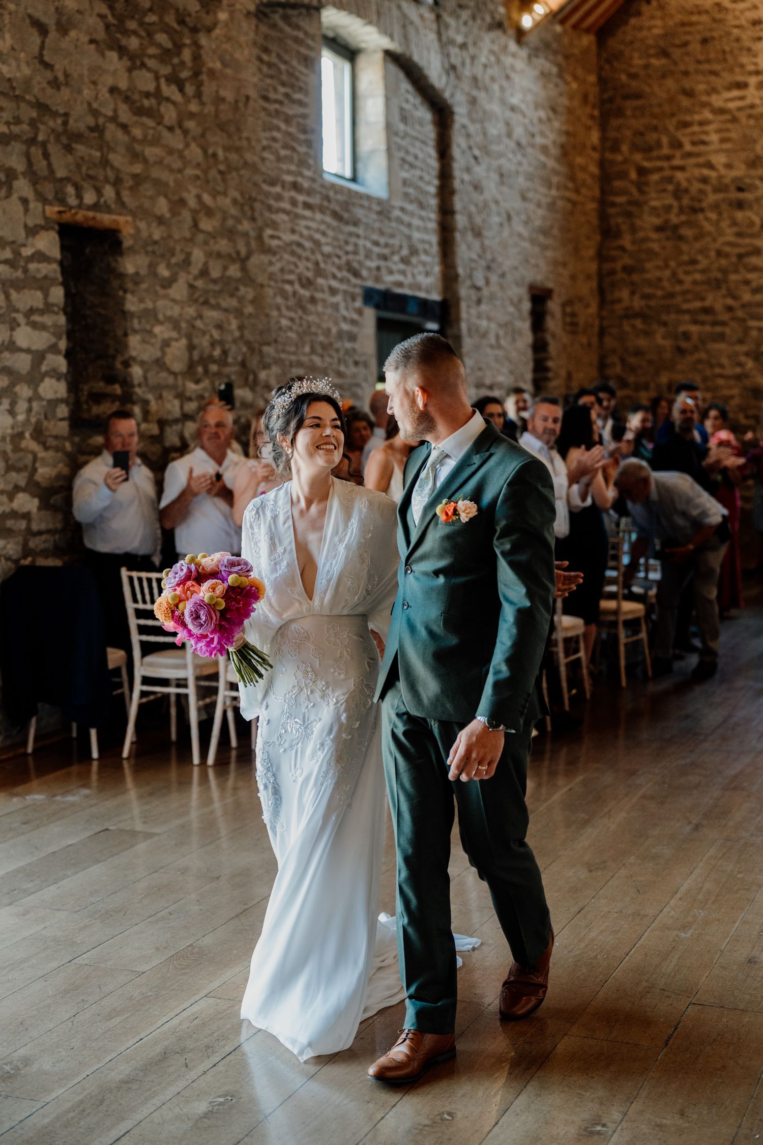 Wedding celebration in a rustic stone barn venue with couples dancing on wooden floors.