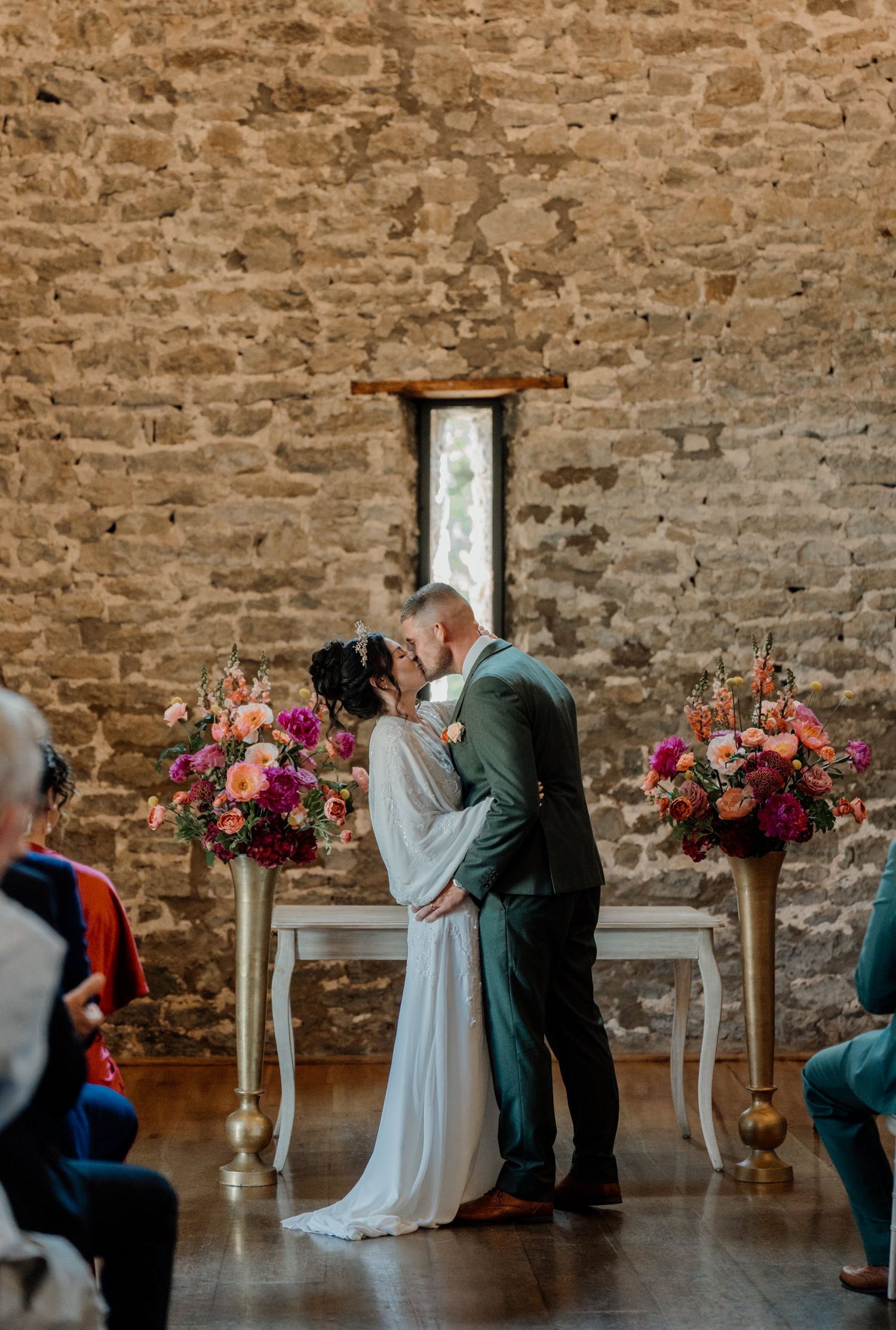 Sequence of wedding moments showing a proposal in a rustic stone-walled venue with vibrant floral arrangements on pedestals.