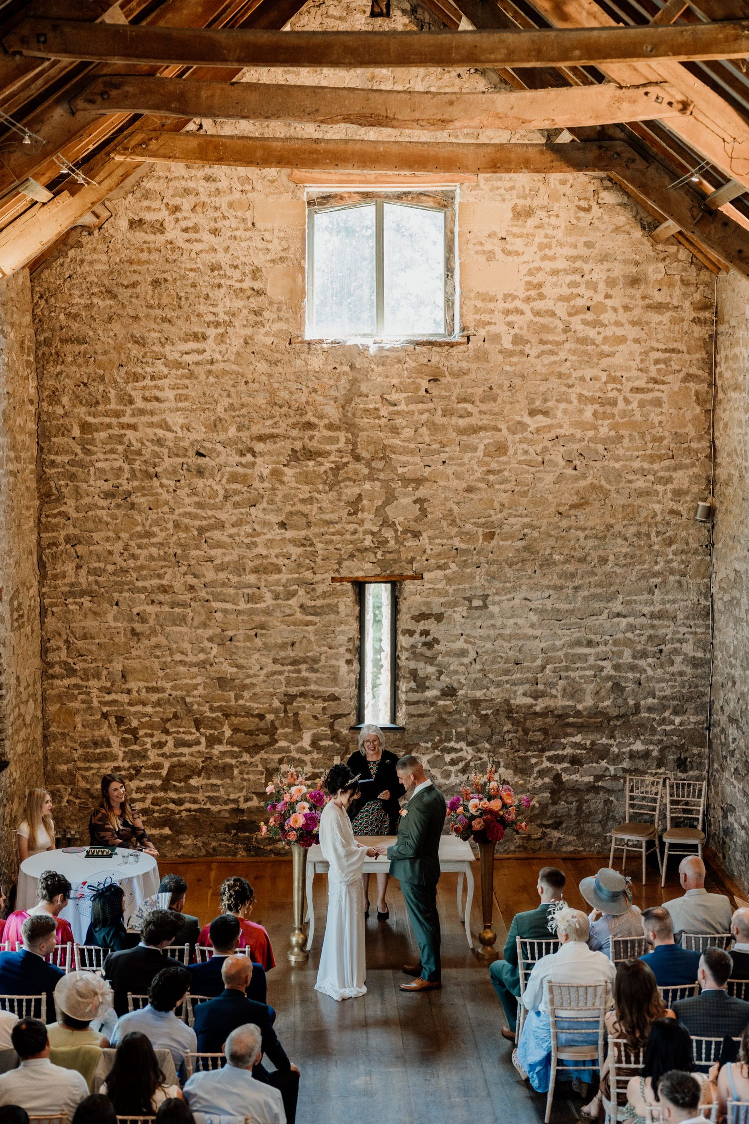 Wedding ceremony set up at Priston Mill in Bath, with white chairs and natural lighting from windows.