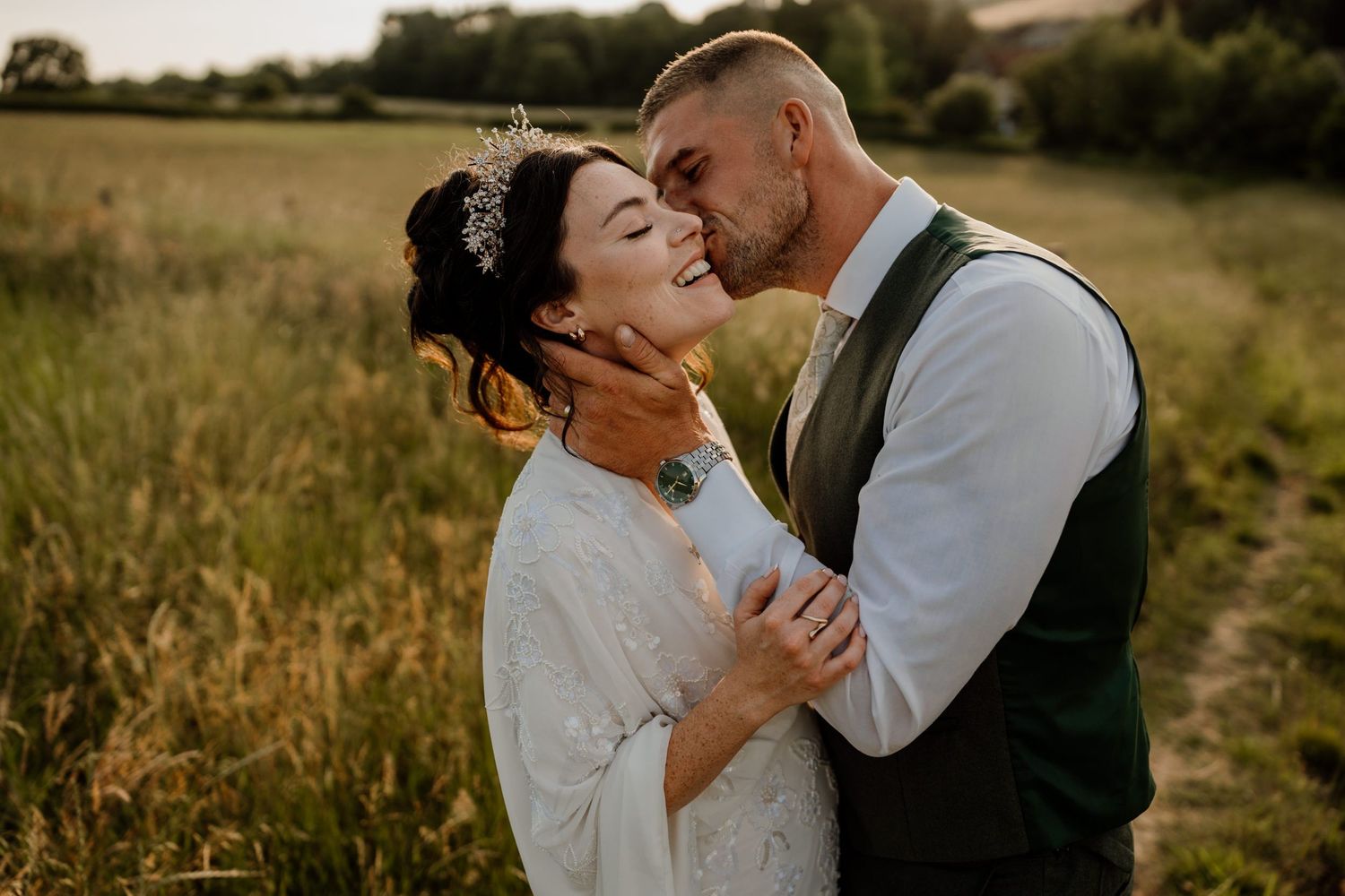Couple dancing together in a golden field during sunset.