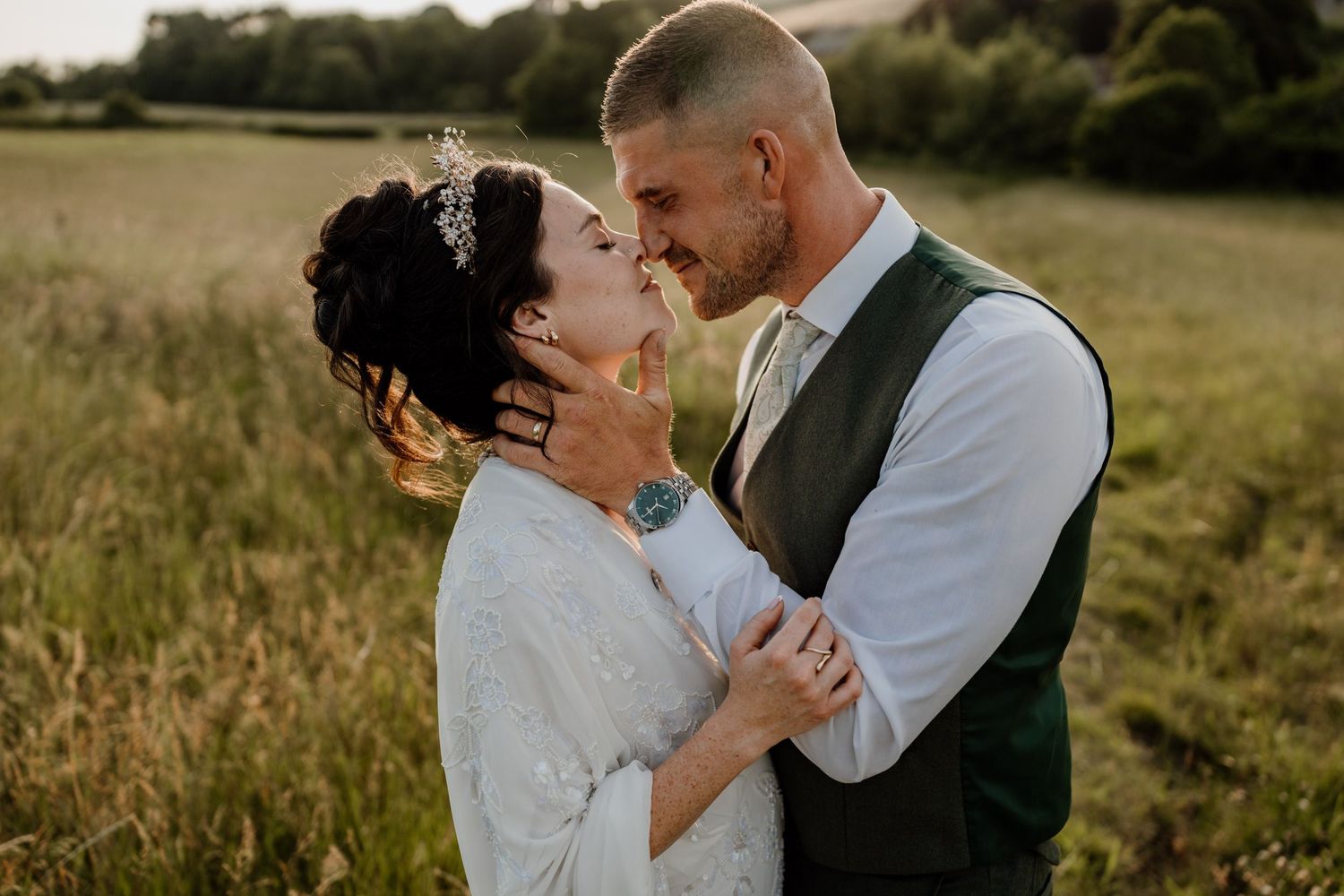 Intimate wedding couple portrait session in a golden sunset field.