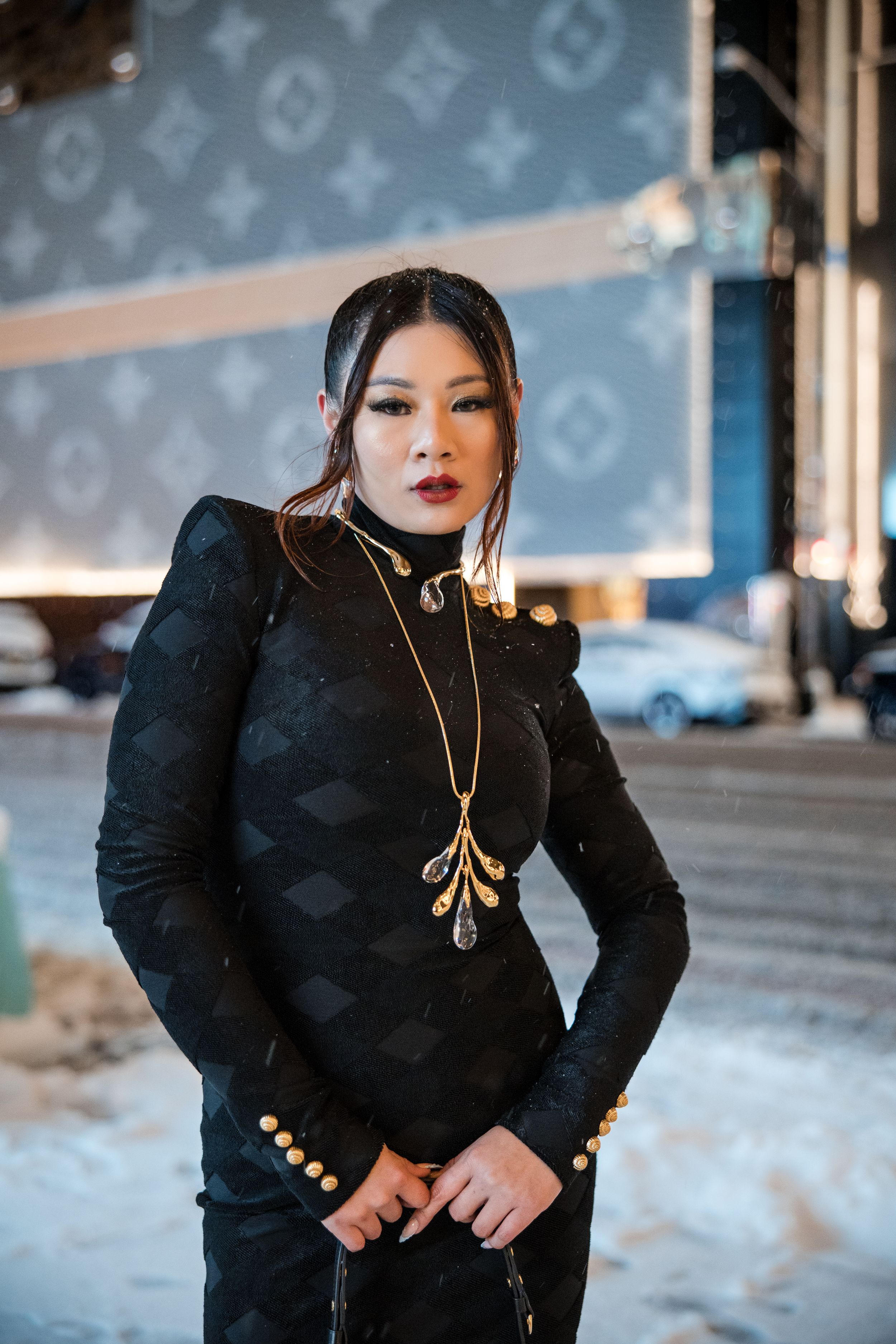 Model wearing elegant black outfit poses in series of fashion photos with blurred background.