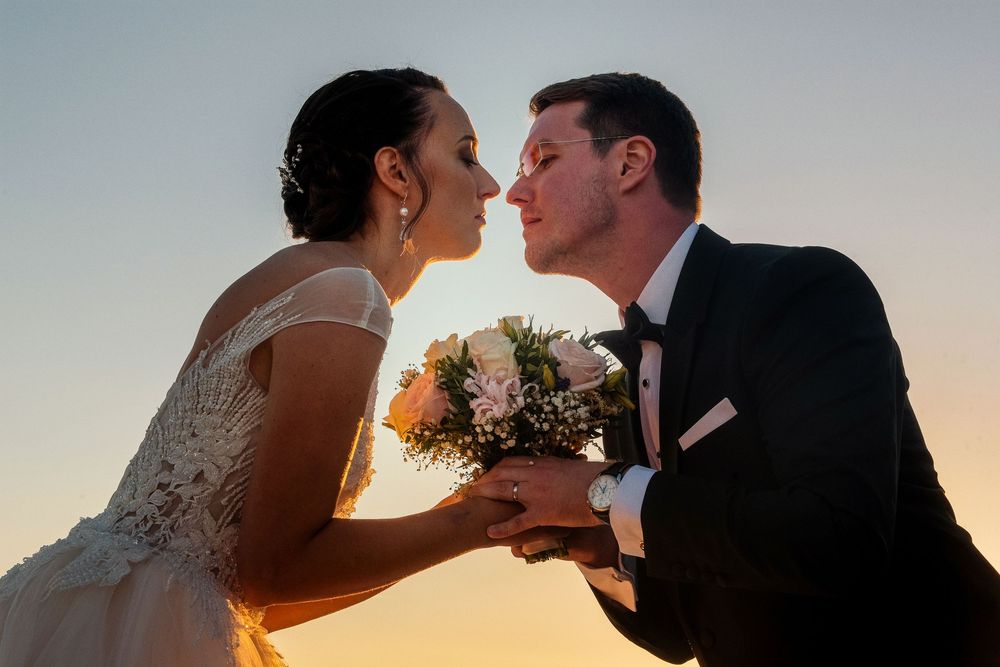 Romantic sunset wedding photos showing tender moments between newlyweds.